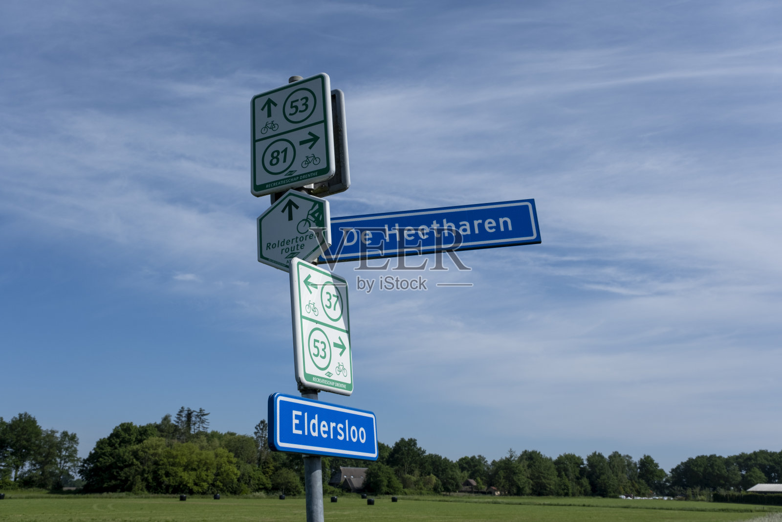 蔚蓝的天空中，德伦特省的荷兰自行车路线指示牌上有典型的荷兰名字，照片摄影图片
