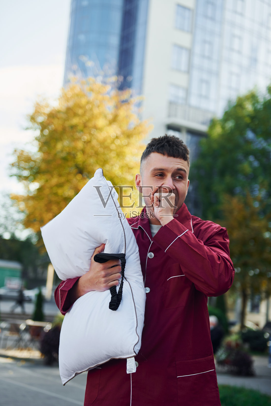 一个穿着睡衣的年轻人走在大街上。感觉困了照片摄影图片