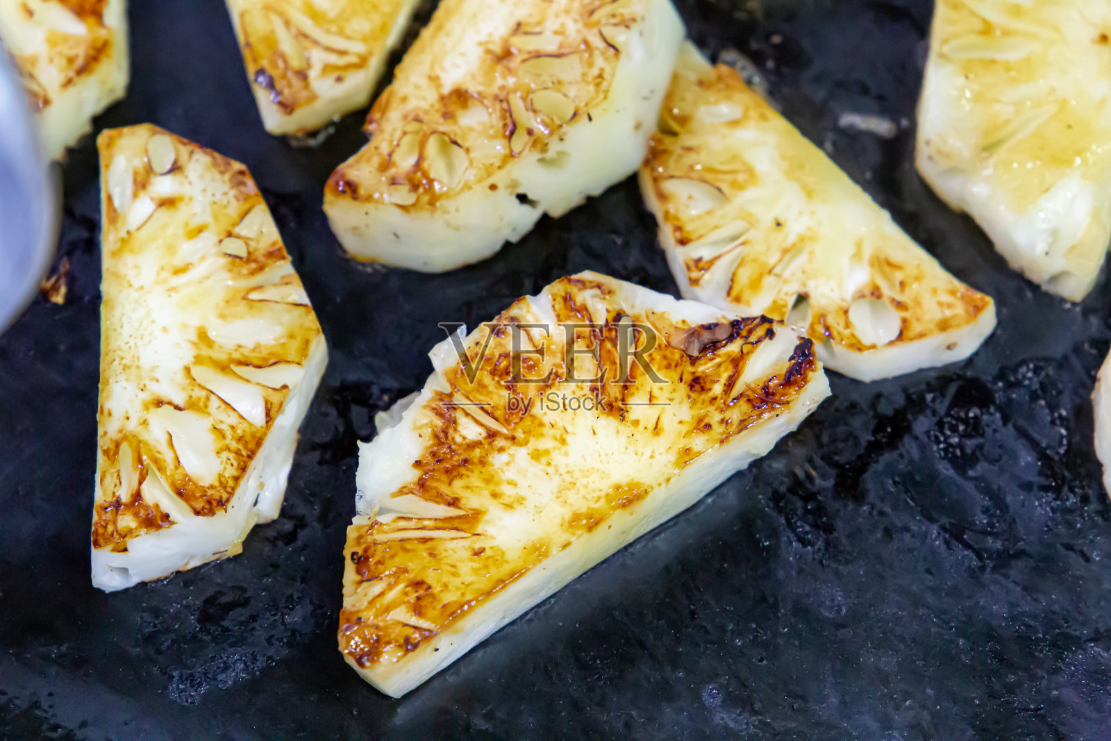 许多人在巴西的餐馆里切菠萝。巴西的食物照片摄影图片