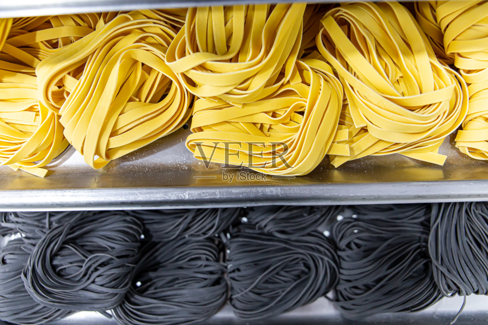 在一家意大利餐馆里制作面条。绿色的面条照片摄影图片