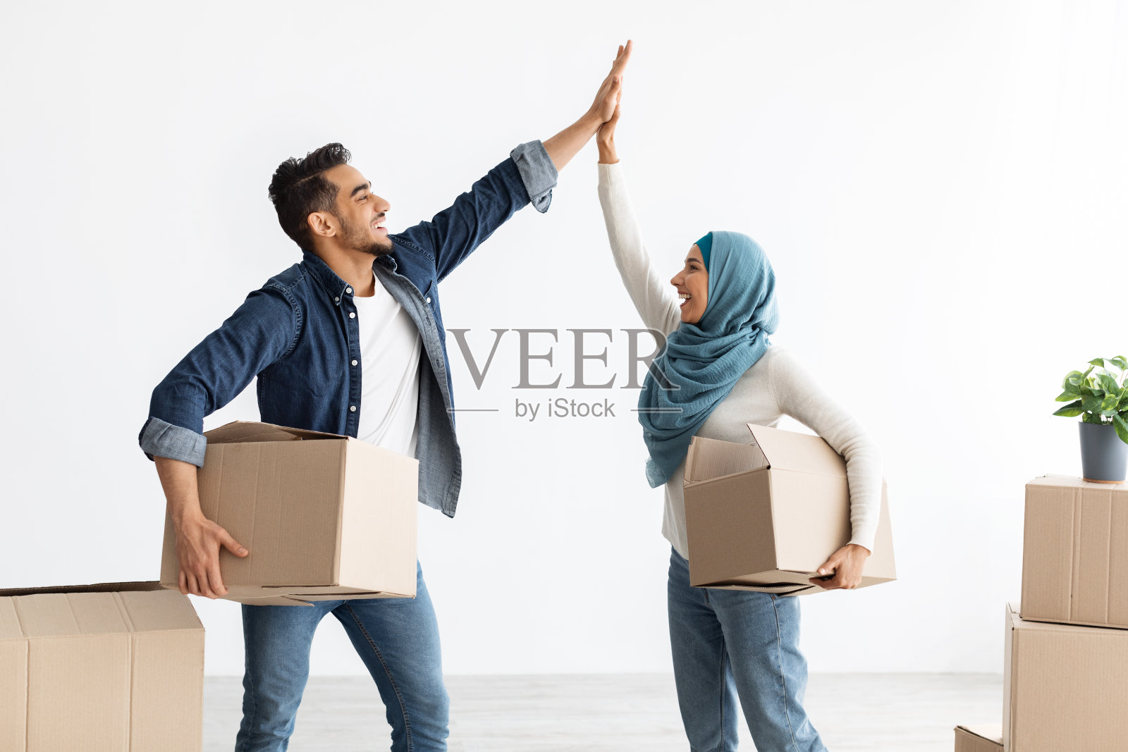 充满爱意的穆斯林家庭在空房间里击掌照片摄影图片