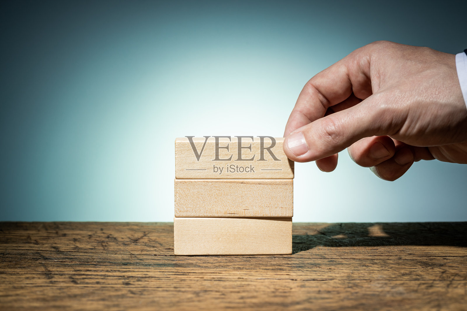 商人手持空白木块创造概念创意结构。商业图表模板的模型。蓝色背景。项目的布局照片摄影图片