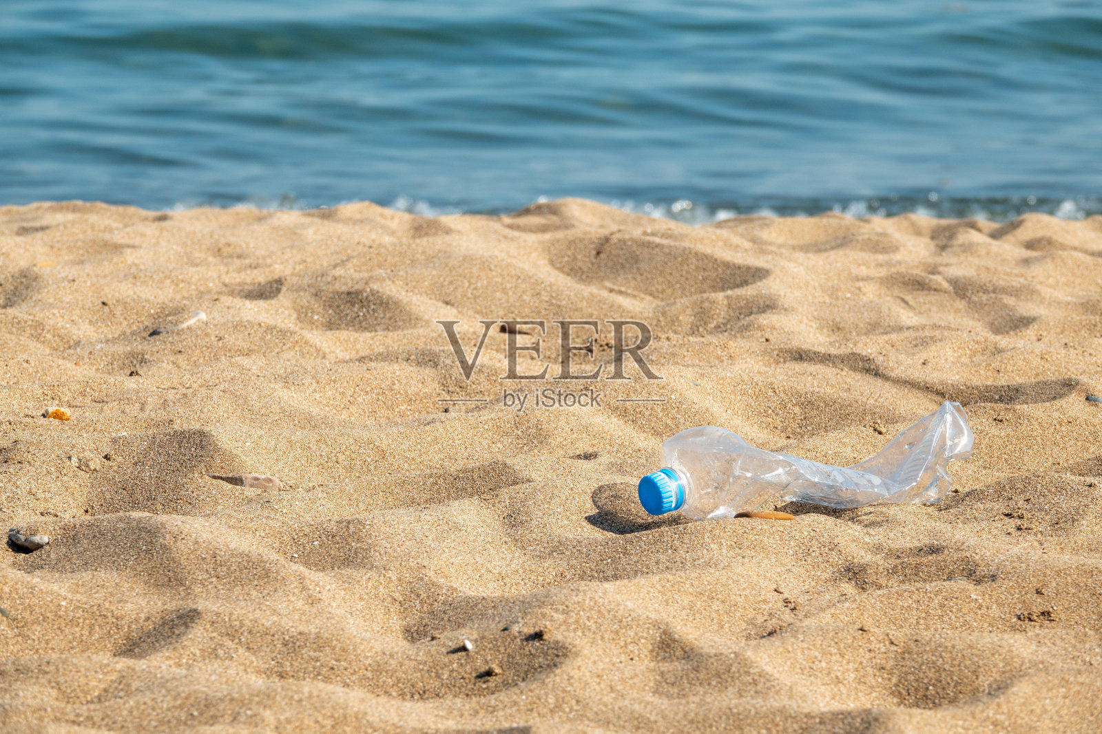 海滩上有游客留下的塑料瓶照片摄影图片