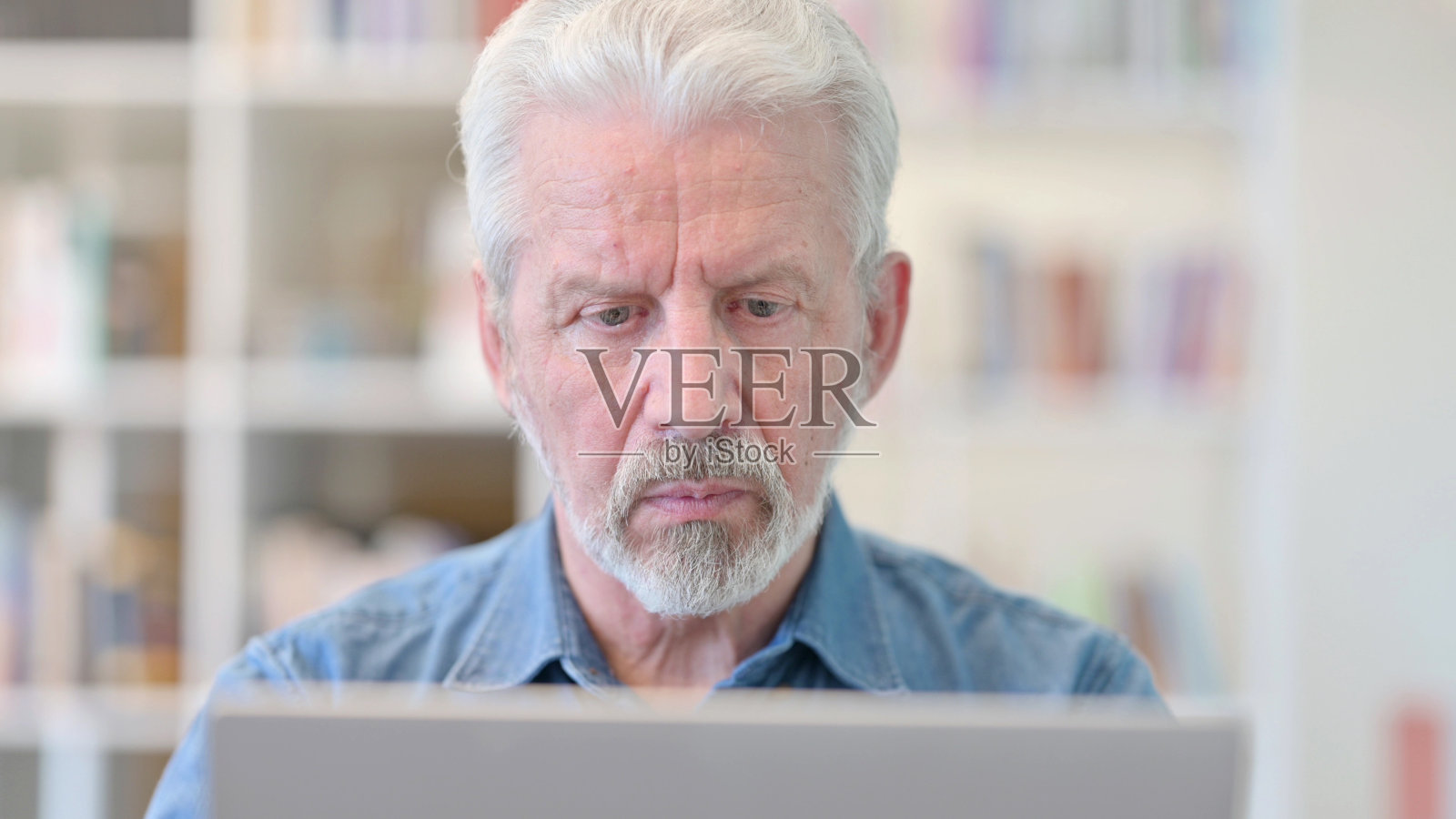 专注的老商人在笔记本电脑上工作照片摄影图片