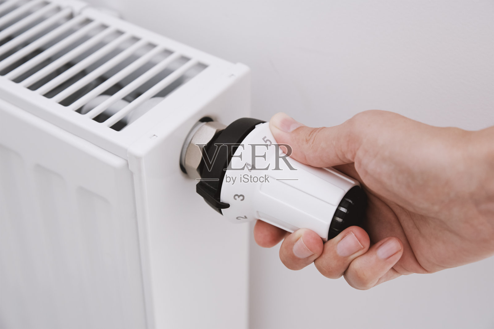 女人手调节散热器的温度照片摄影图片