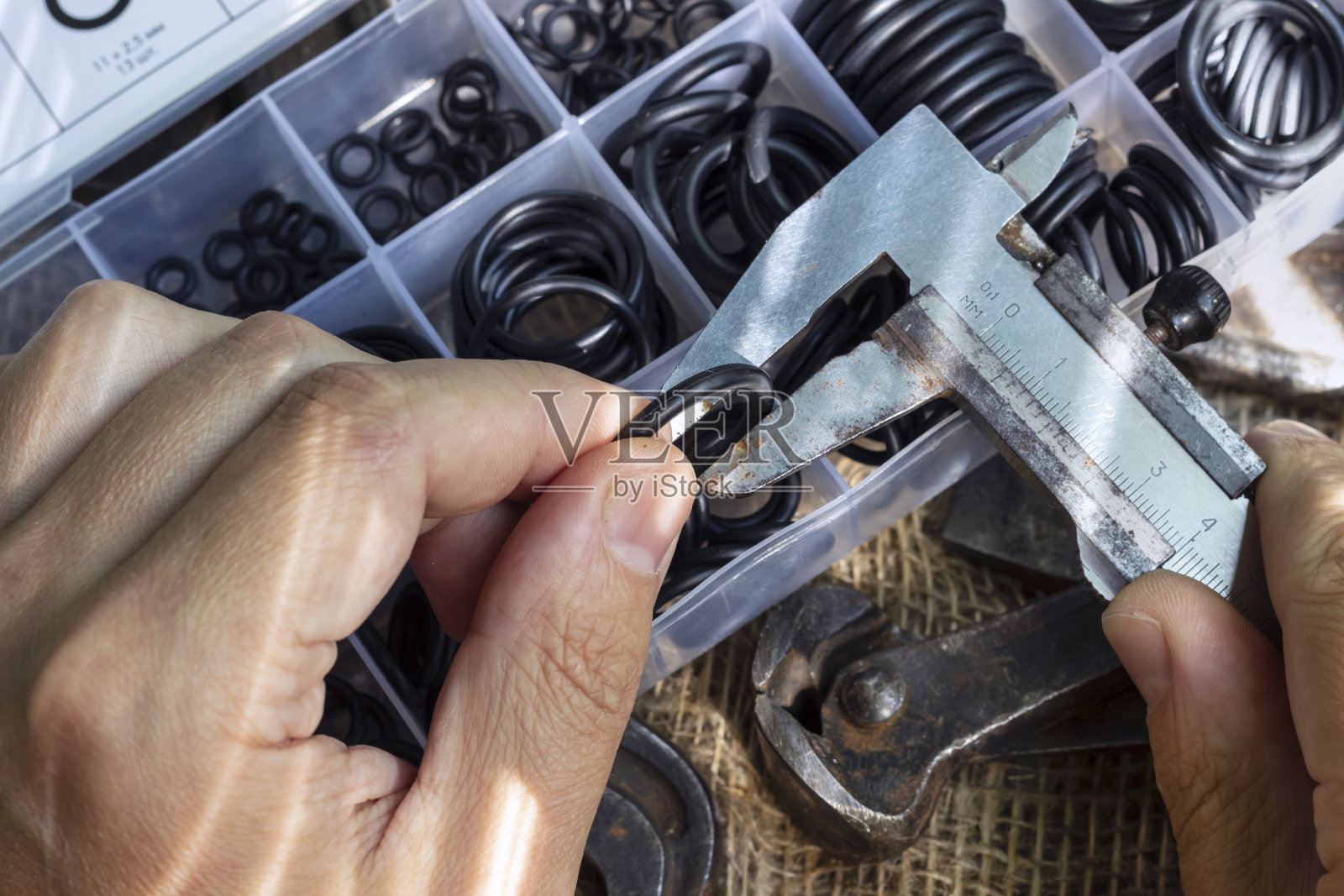 用卡尺测量橡胶圈的直径。照片摄影图片