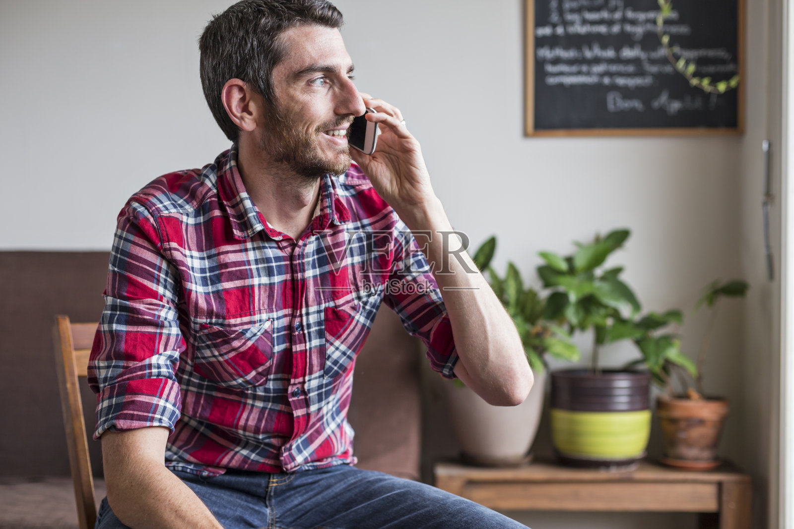 一名男子坐在椅子上玩手机聊天照片摄影图片