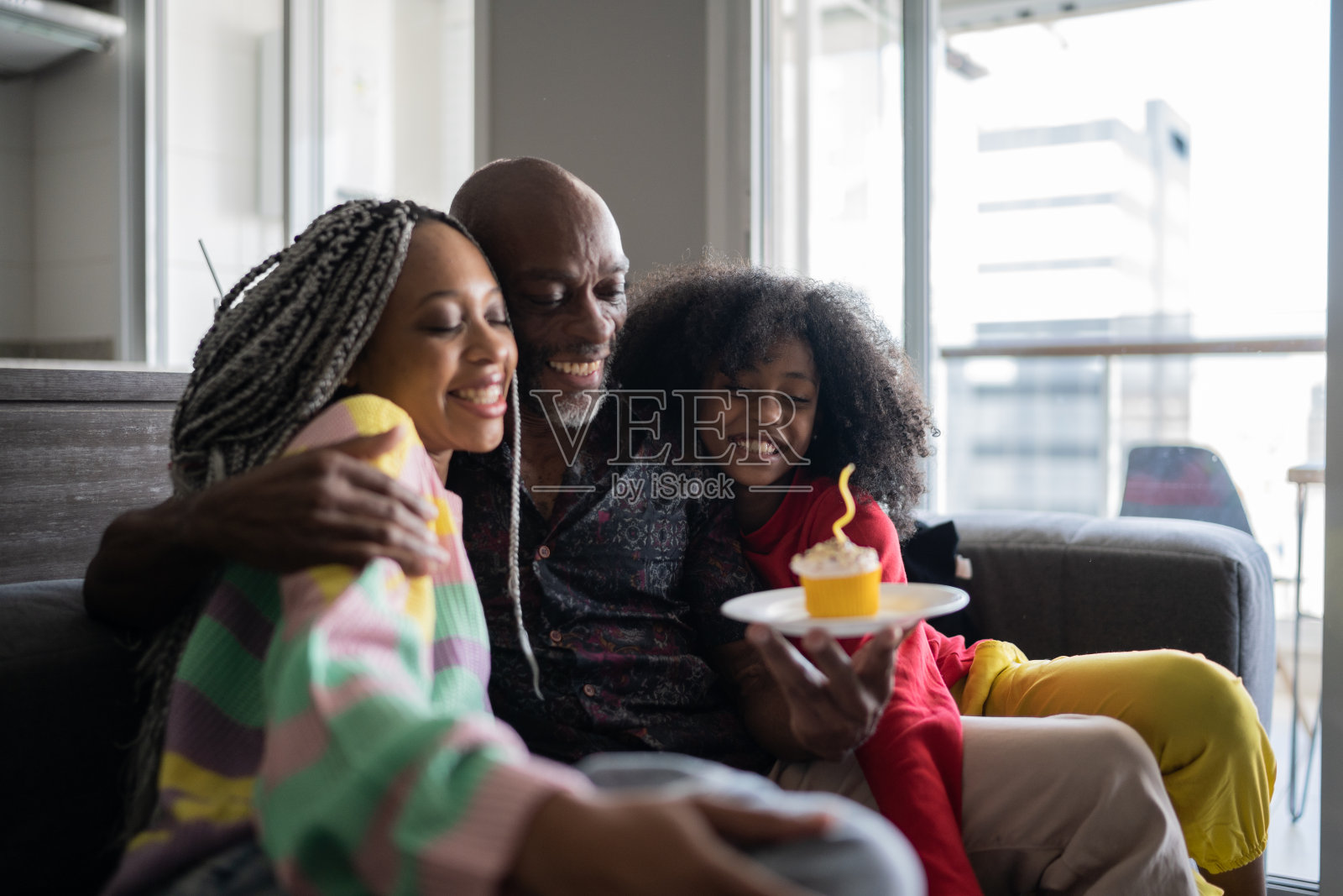 女儿们在家为父亲庆祝生日，送上纸杯蛋糕照片摄影图片