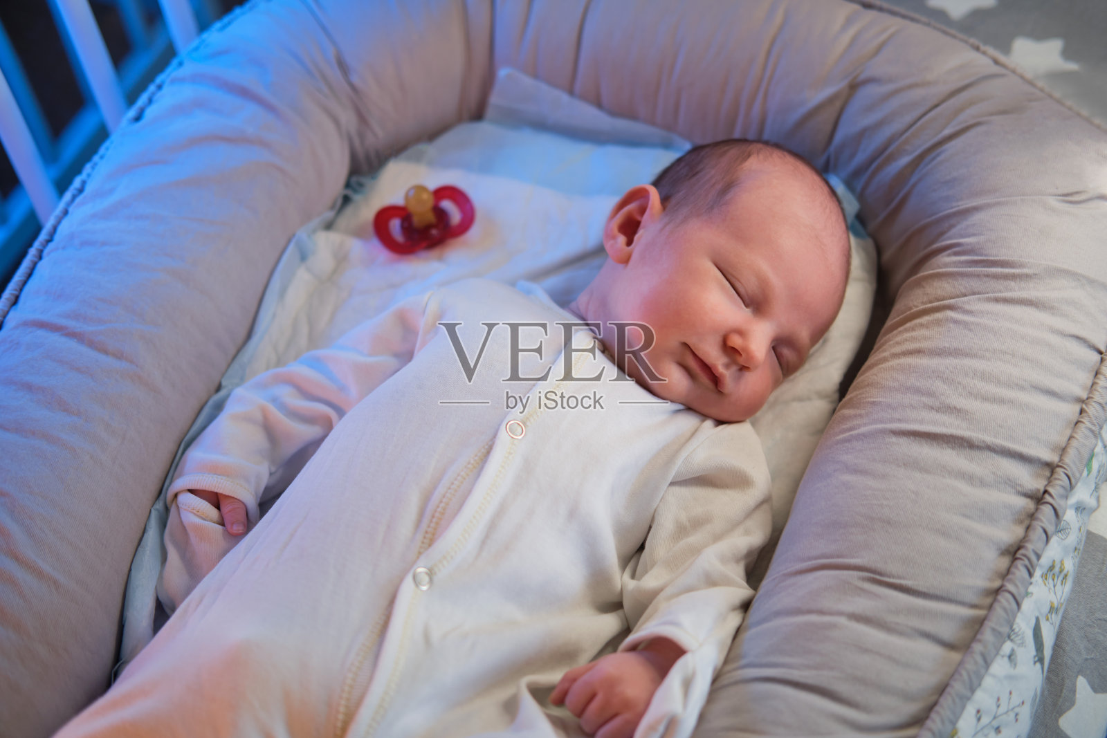 一个月大的男婴睡在婴儿床上。白人小孩在孩子的卧室里照片摄影图片