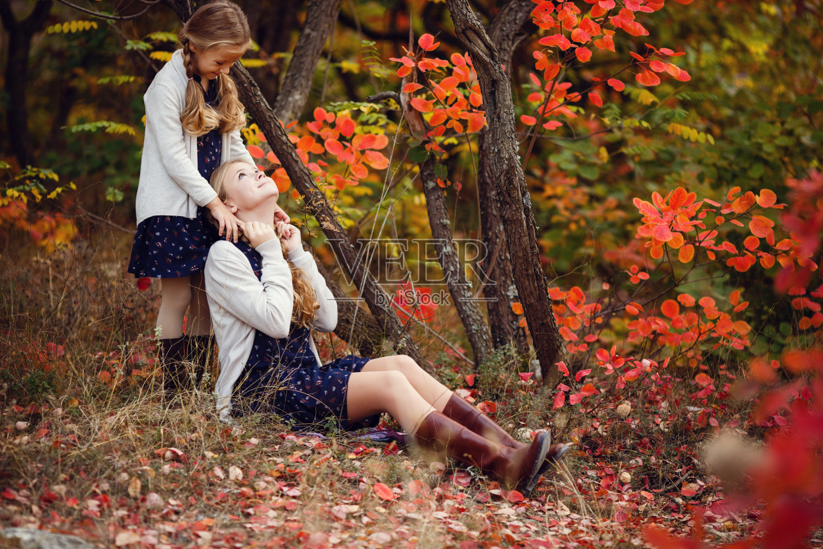 温暖的秋日里，两个欢快的姐妹在公园里玩耍照片摄影图片