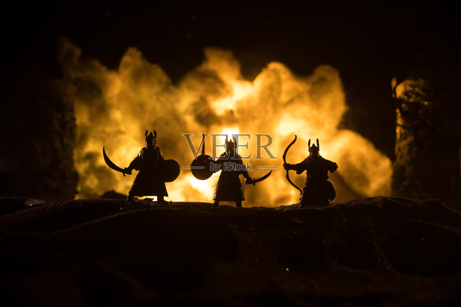 中世纪骑兵和步兵的战斗场景。人物的轮廓作为独立的对象，战士之间的战斗与中世纪城堡的黑暗色调雾蒙蒙的背景。照片摄影图片