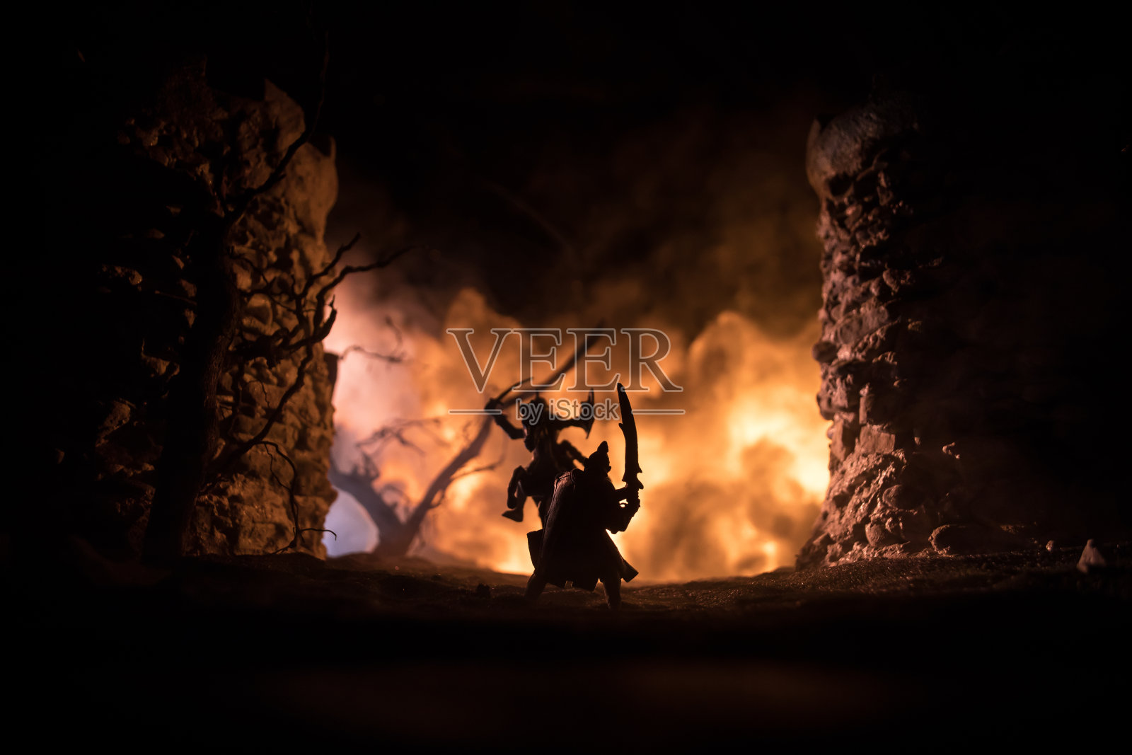 中世纪骑兵和步兵的战斗场景。人物的轮廓作为独立的对象，战士之间的战斗与中世纪城堡的黑暗色调雾蒙蒙的背景。照片摄影图片