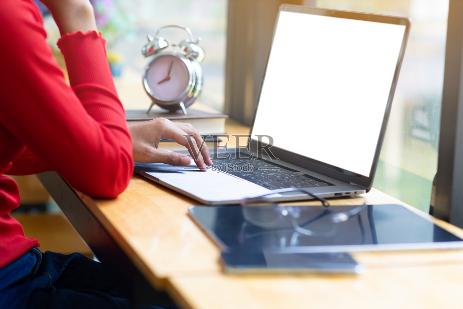 在办公室桌上用笔记本电脑工作的女人。照片摄影图片