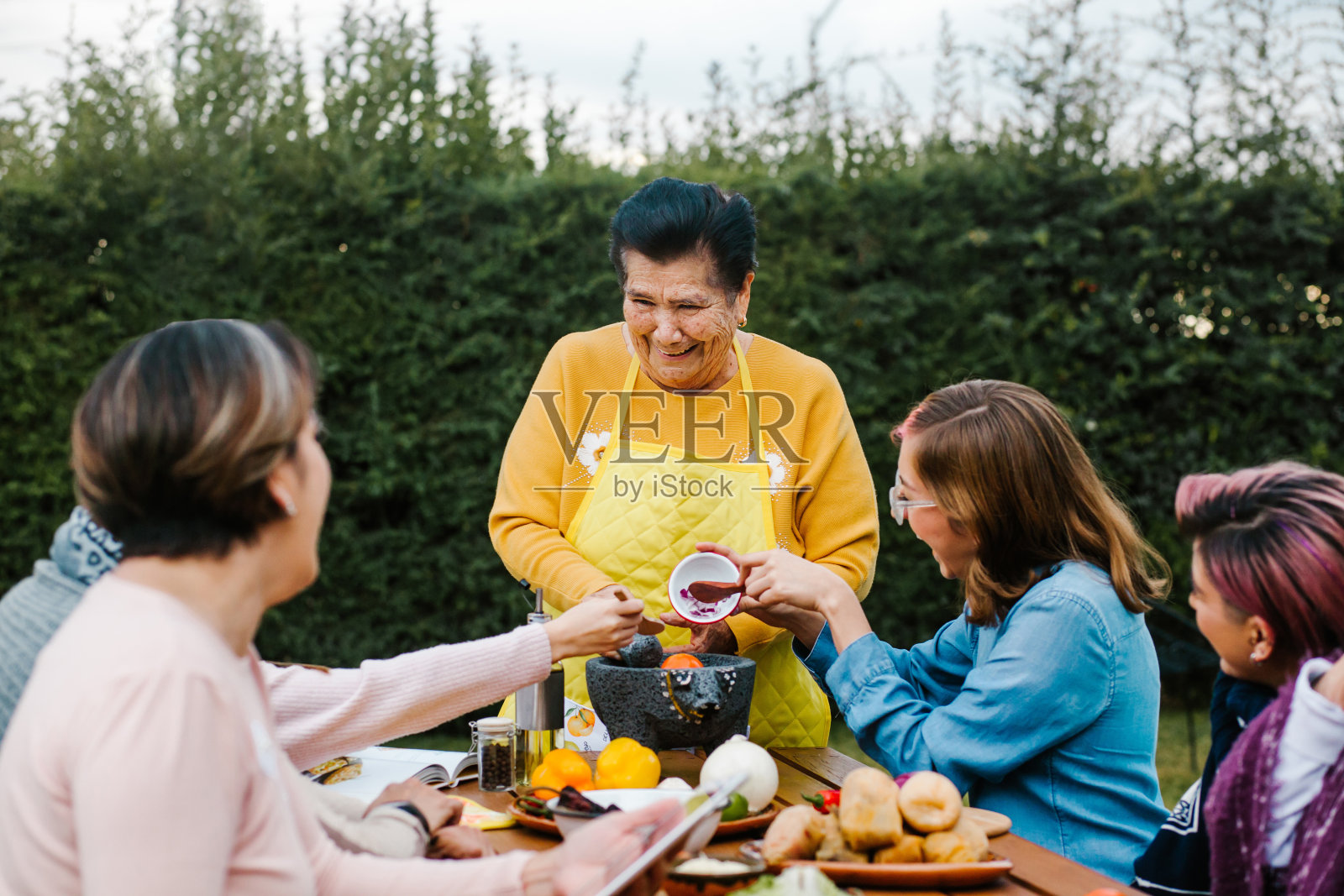 拉丁祖母和外孙女，女儿在家做墨西哥菜，墨西哥三代妇女照片摄影图片