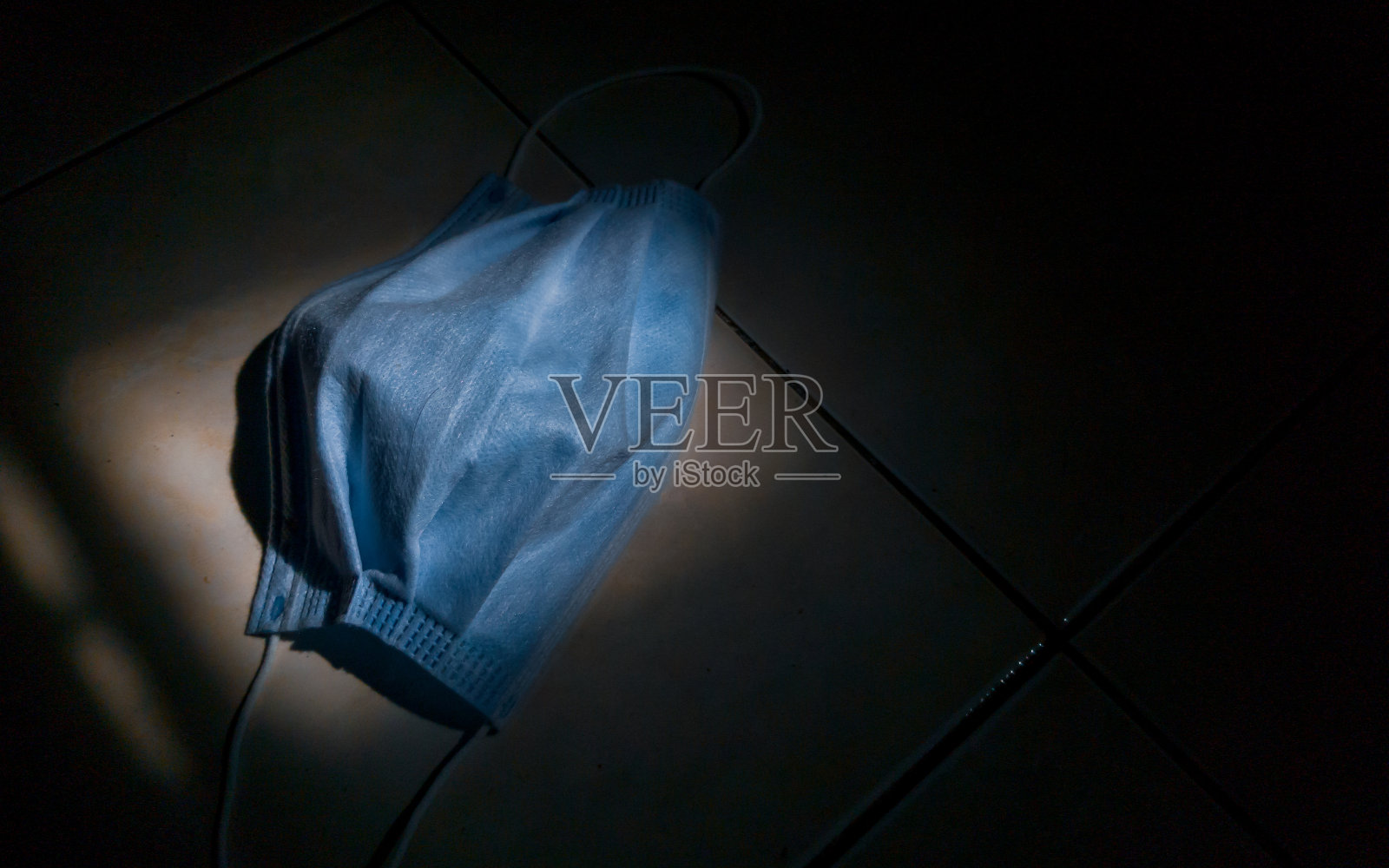 地板上有医用口罩，周围有黑色背景照片摄影图片