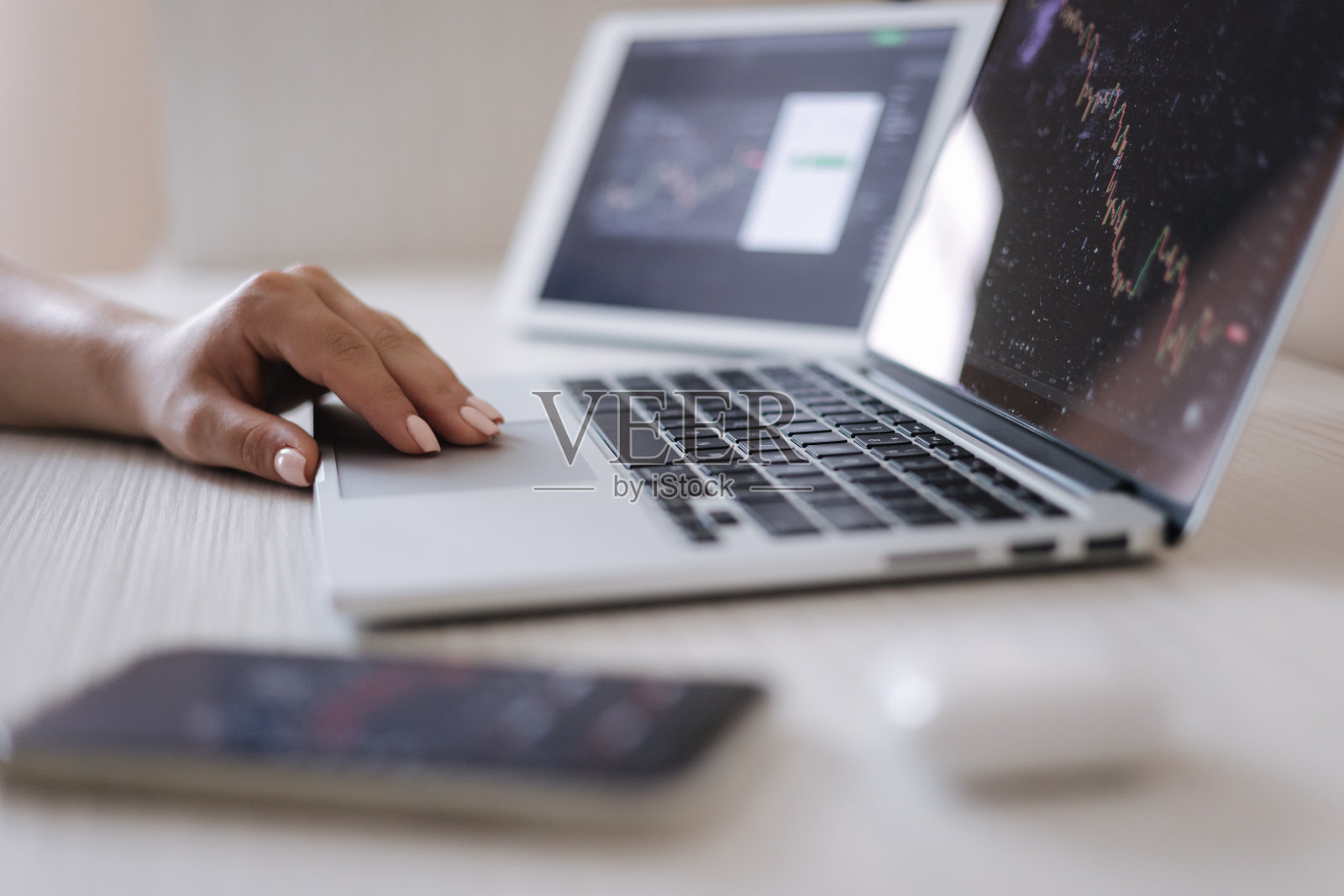 女性通过在线培训赚钱的近况。一名男子用笔记本电脑、平板电脑和手机作为显示器，推动加密货币股票上涨。家庭理财，投资，经济，存钱或保险的概念照片摄影图片