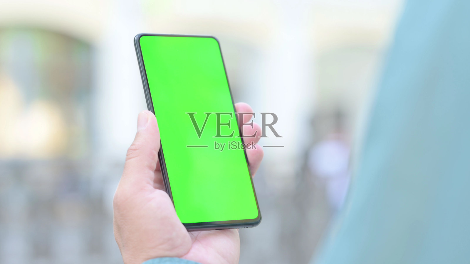 户外男子手持智能手机与绿色色度键屏幕照片摄影图片