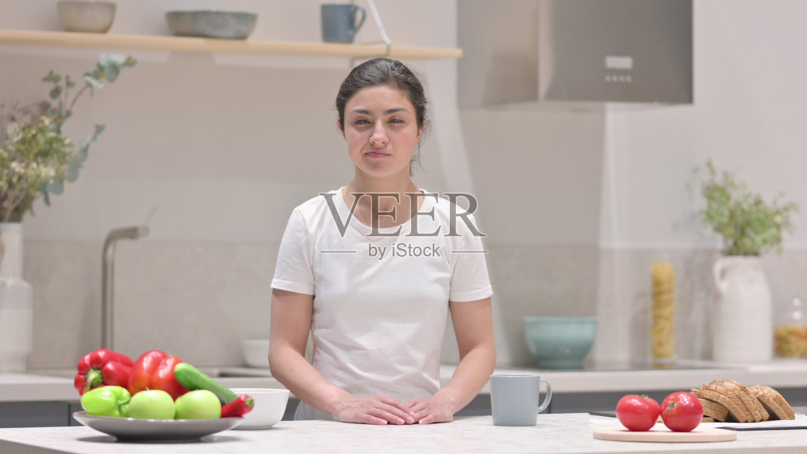 在厨房里，年轻的印度女人摇着头说“没有”照片摄影图片