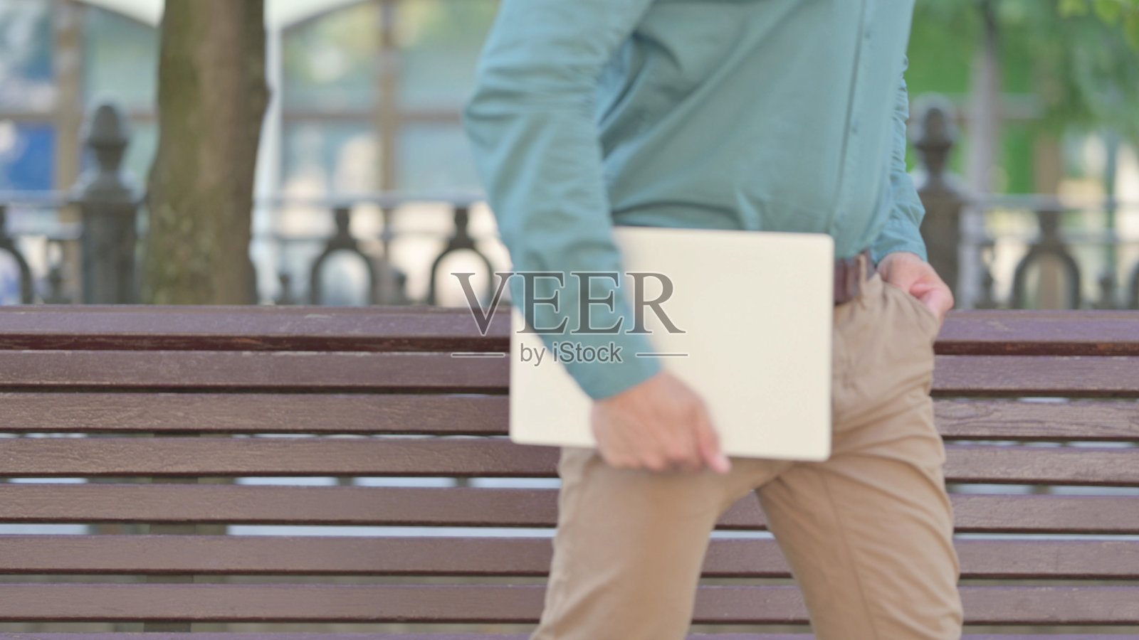 中年男子带着笔记本电脑离开长凳照片摄影图片