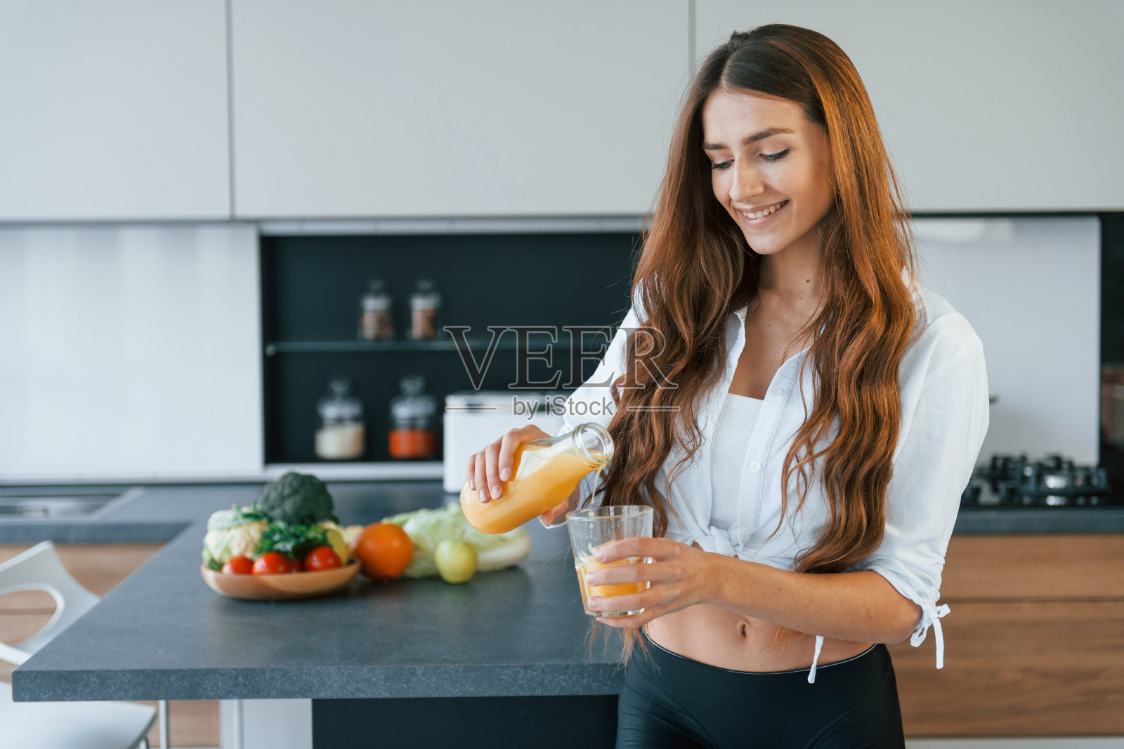 年轻的欧洲妇女在厨房里吃着健康的食物照片摄影图片