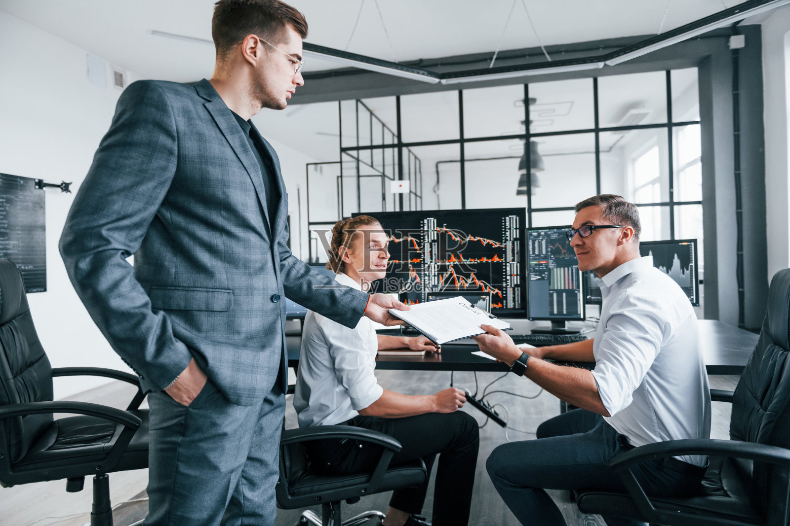 与文件。股票经纪人团队在现代化的办公室里工作，有许多显示屏照片摄影图片