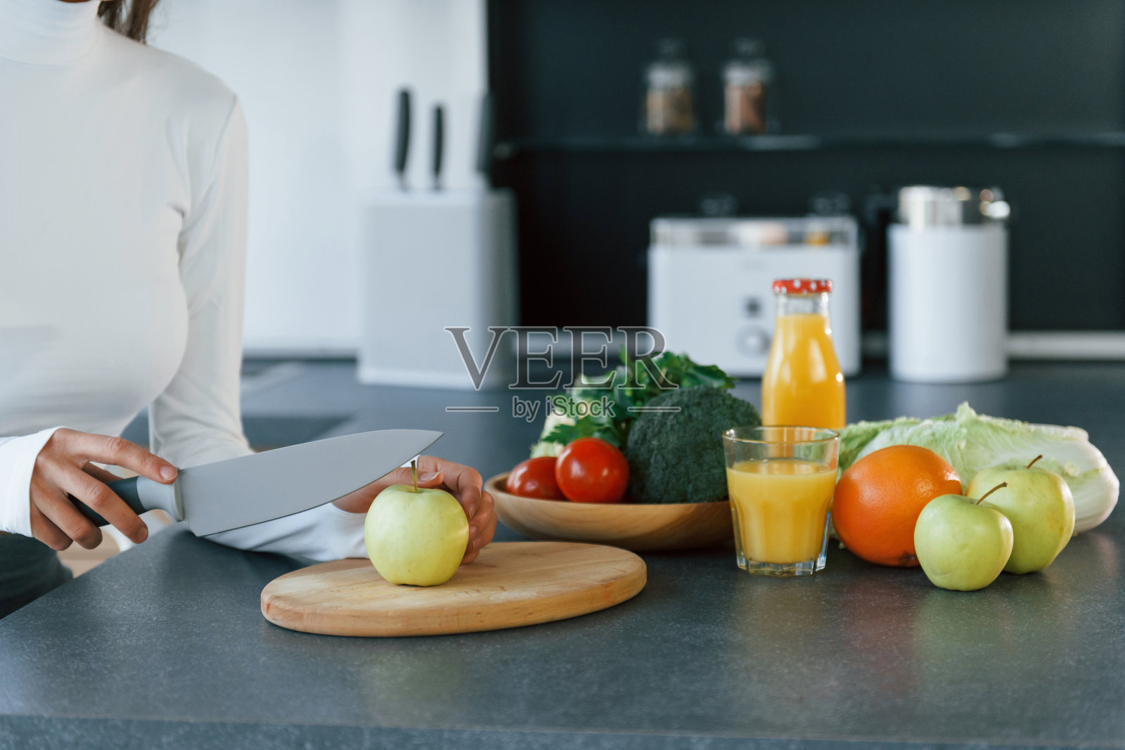 年轻的欧洲妇女在厨房里吃着健康的食物照片摄影图片