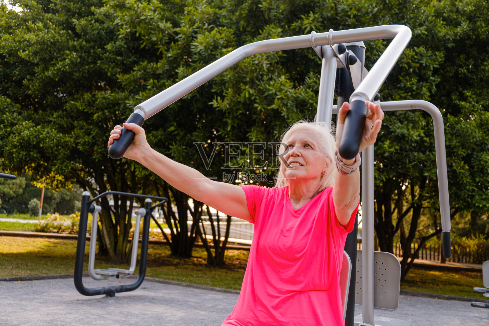 运动的妇女在户外健身房训练。照片摄影图片