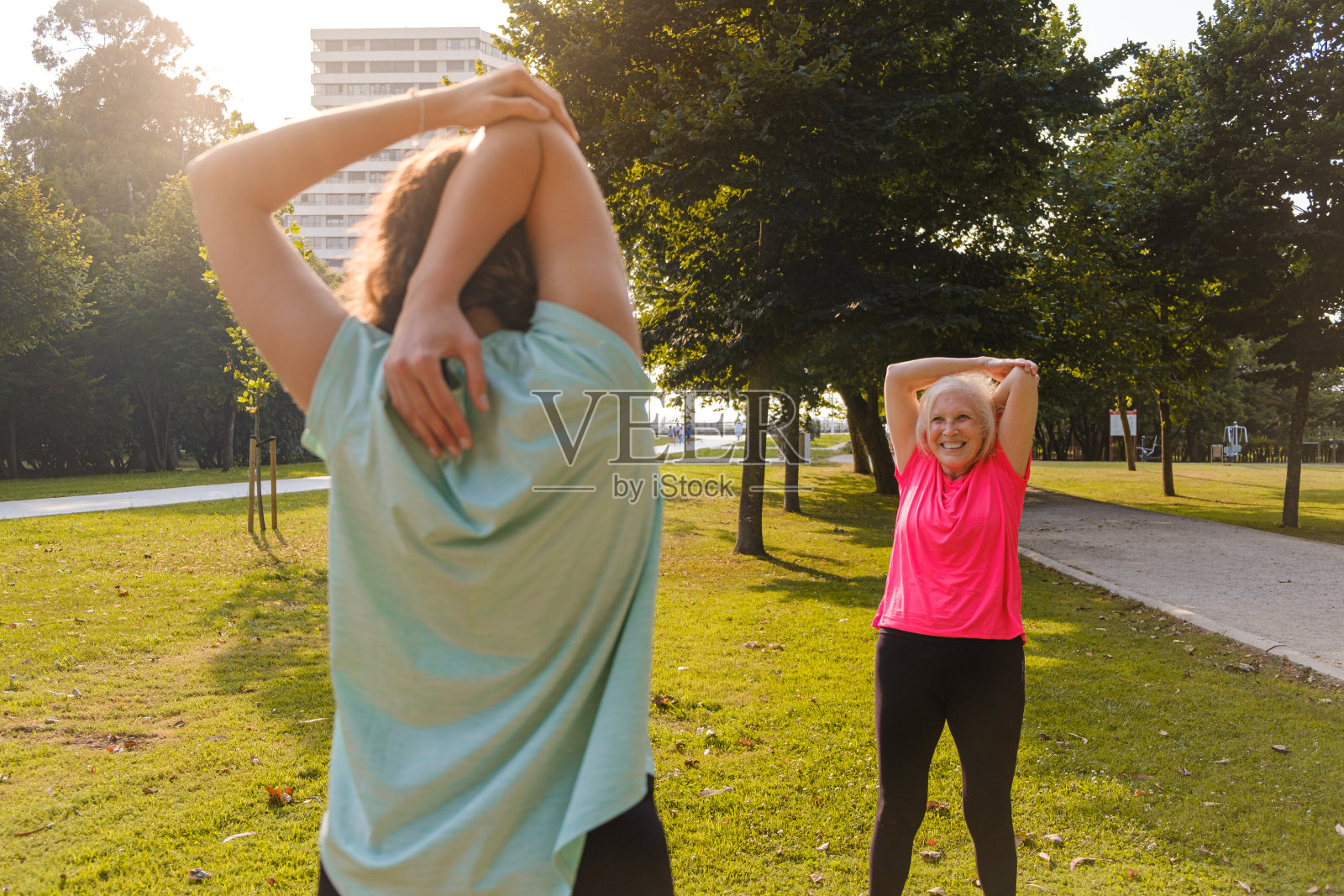 运动的祖母和孙女在公园里伸展身体。照片摄影图片