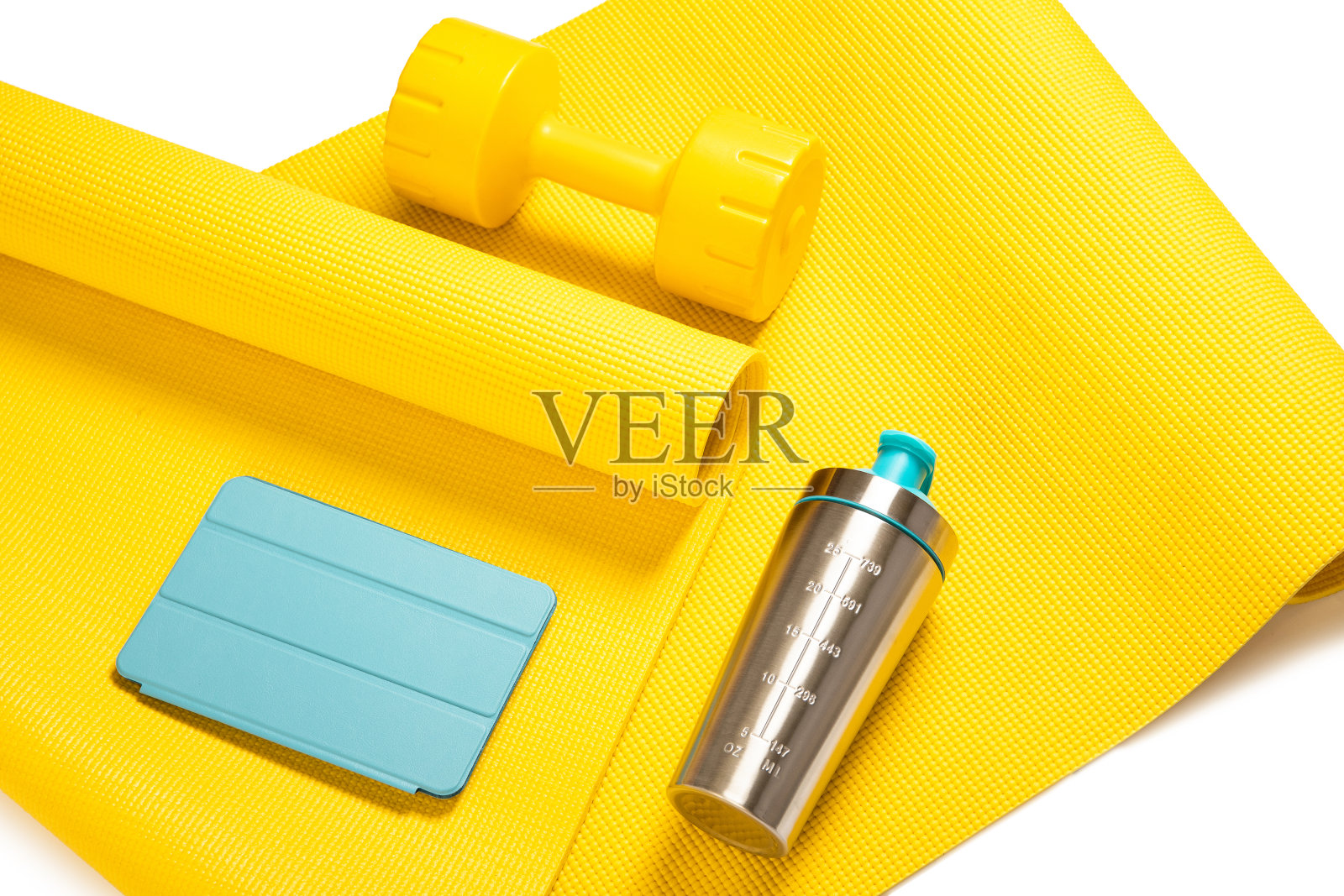 黄色哑铃、摇铃、平板电脑放在健身垫上照片摄影图片