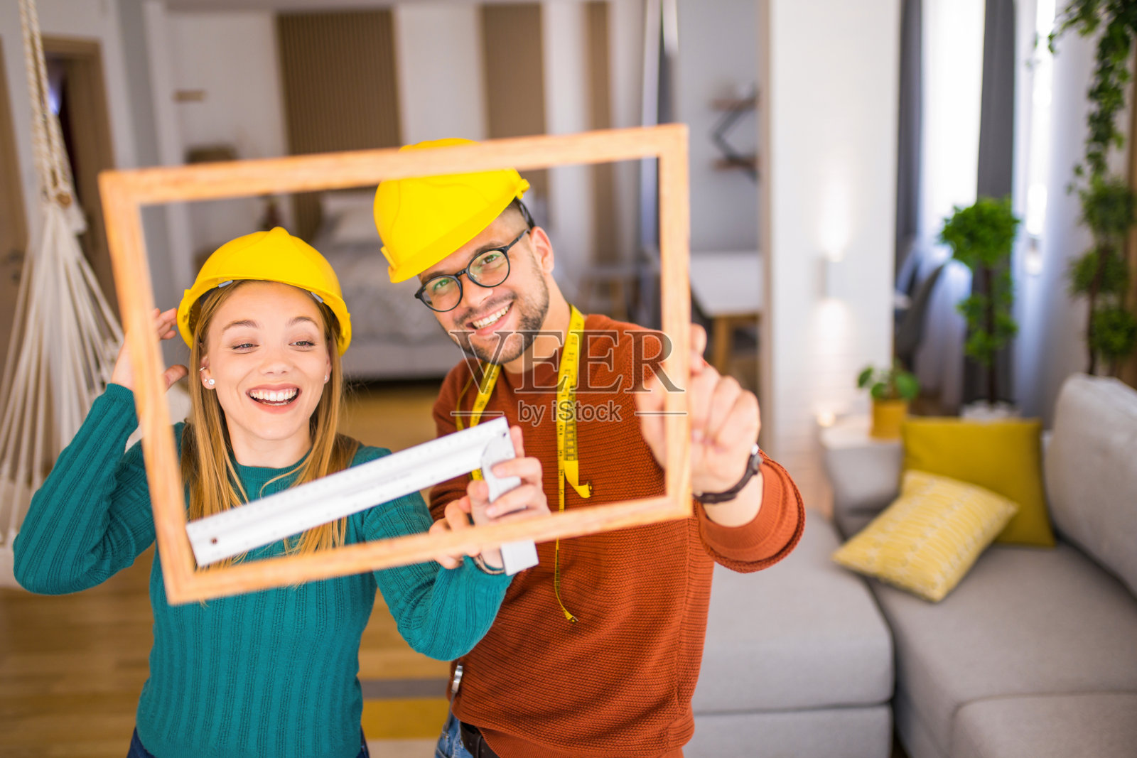 年轻夫妇在装饰他们的家。照片摄影图片