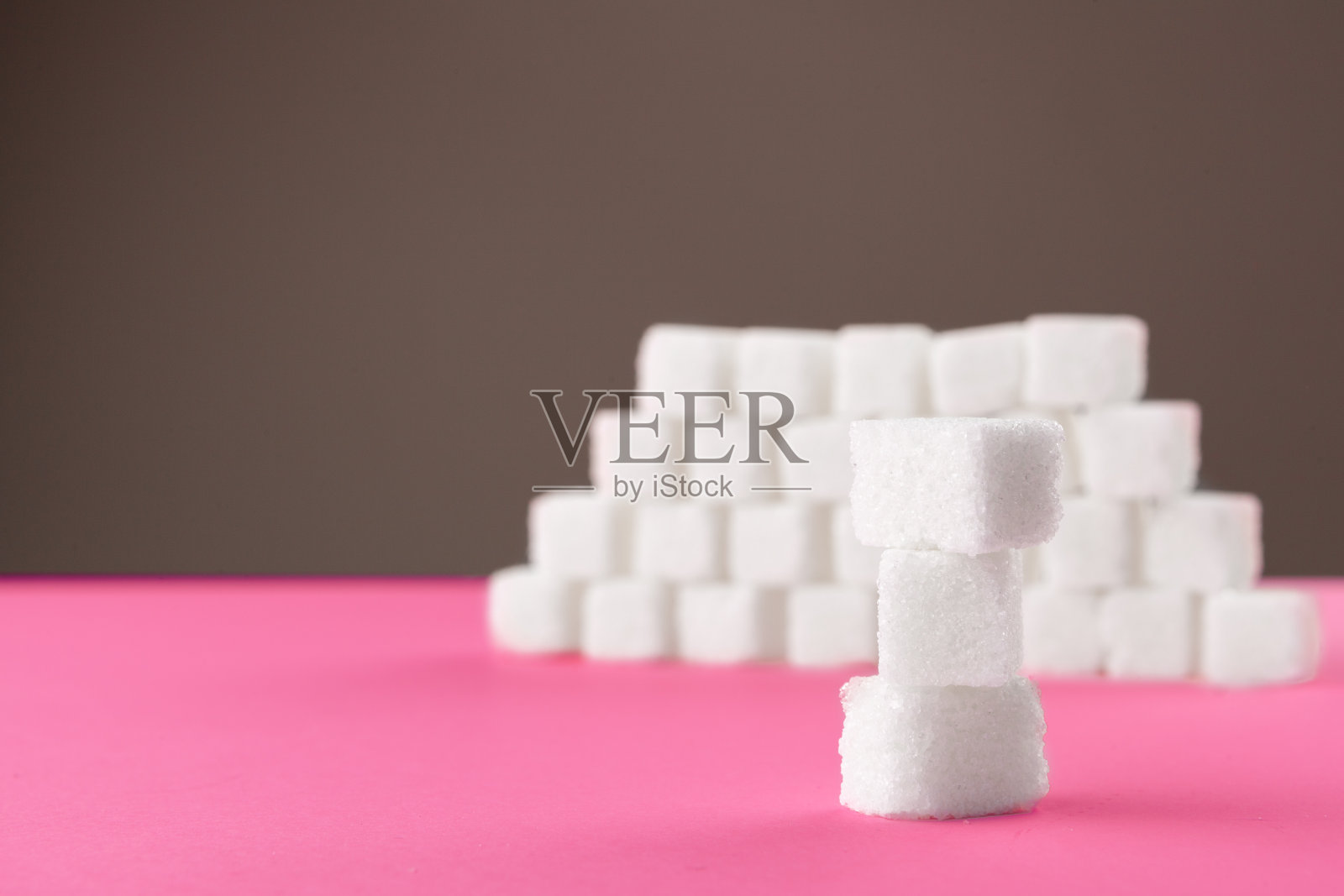 粉色背景上的方糖。为复制文本留出空间照片摄影图片