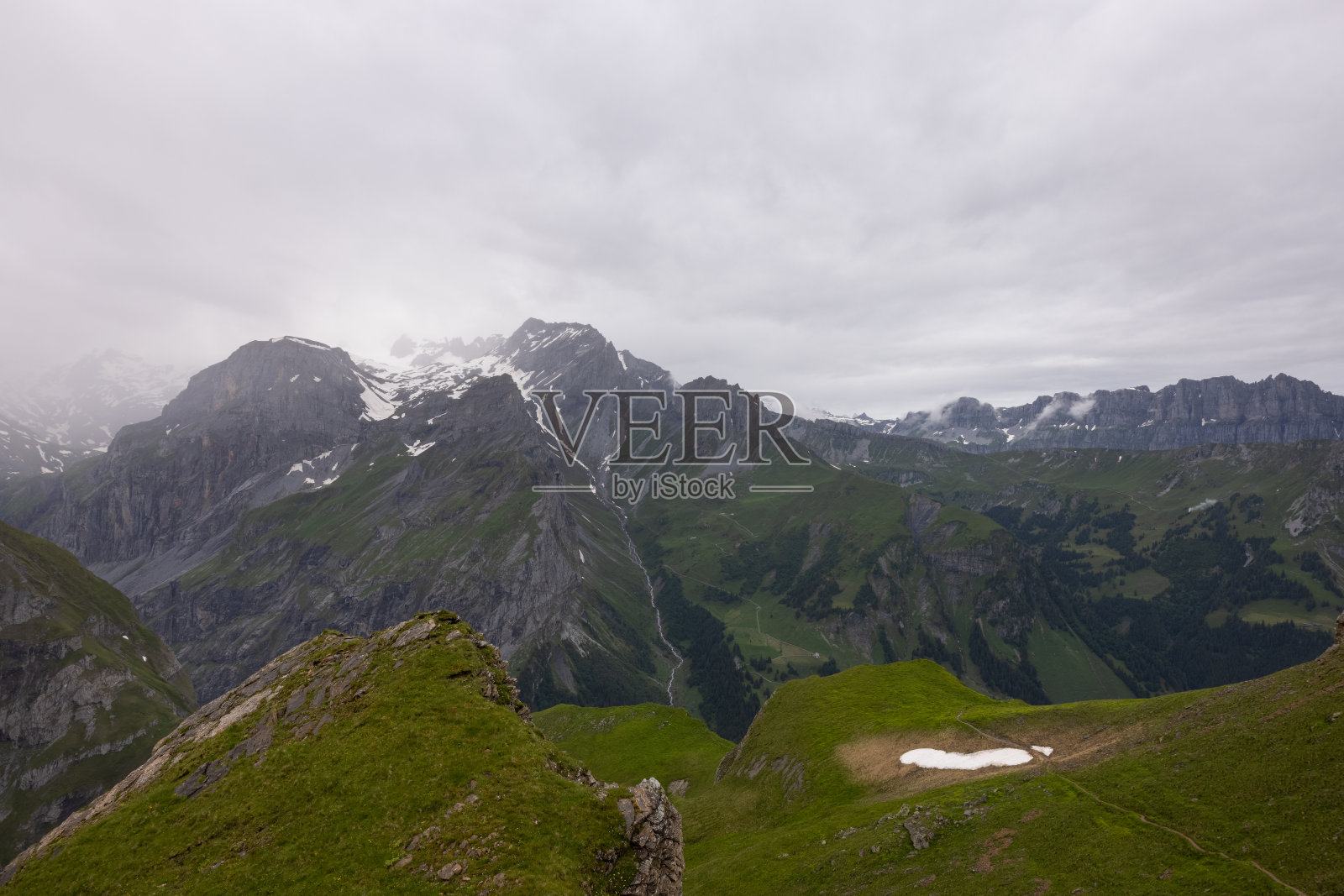 在瑞士的炉边徒步旅行。登上顶峰，翻越阿尔卑斯山，欣赏美丽的风景。史诗般的风景，看起来像霍比特人的土地，指环王。照片摄影图片