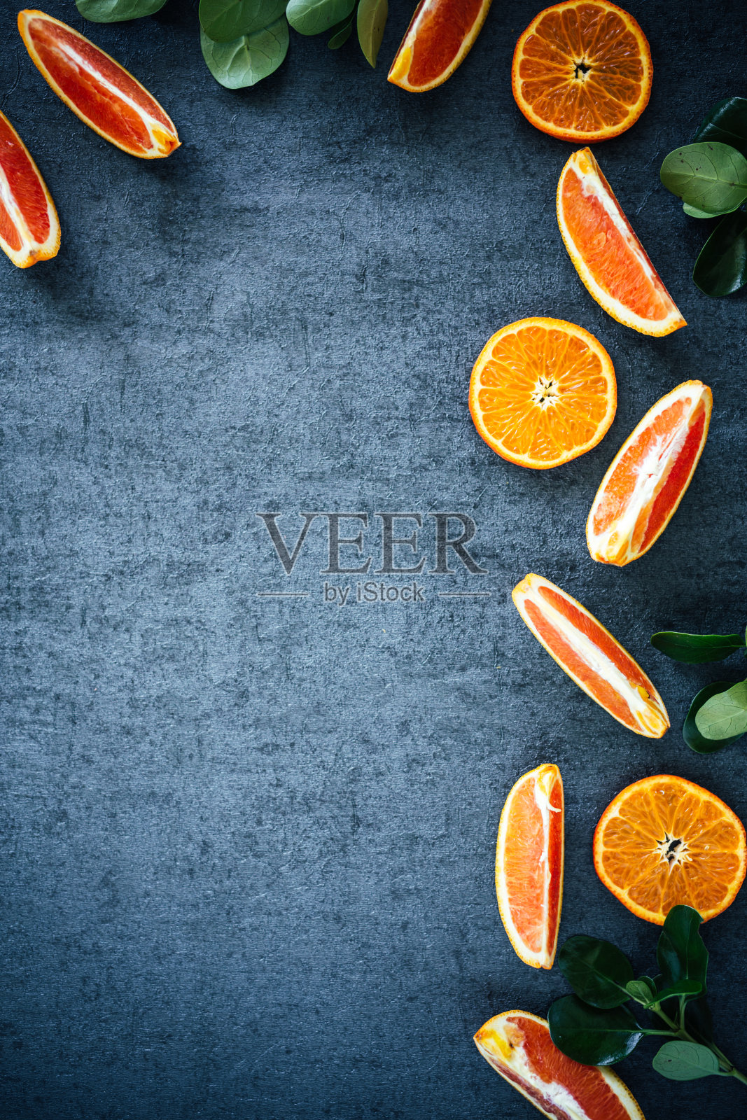 全血橙和柑橘与果皮切片半纹理的背景与绿色照片摄影图片