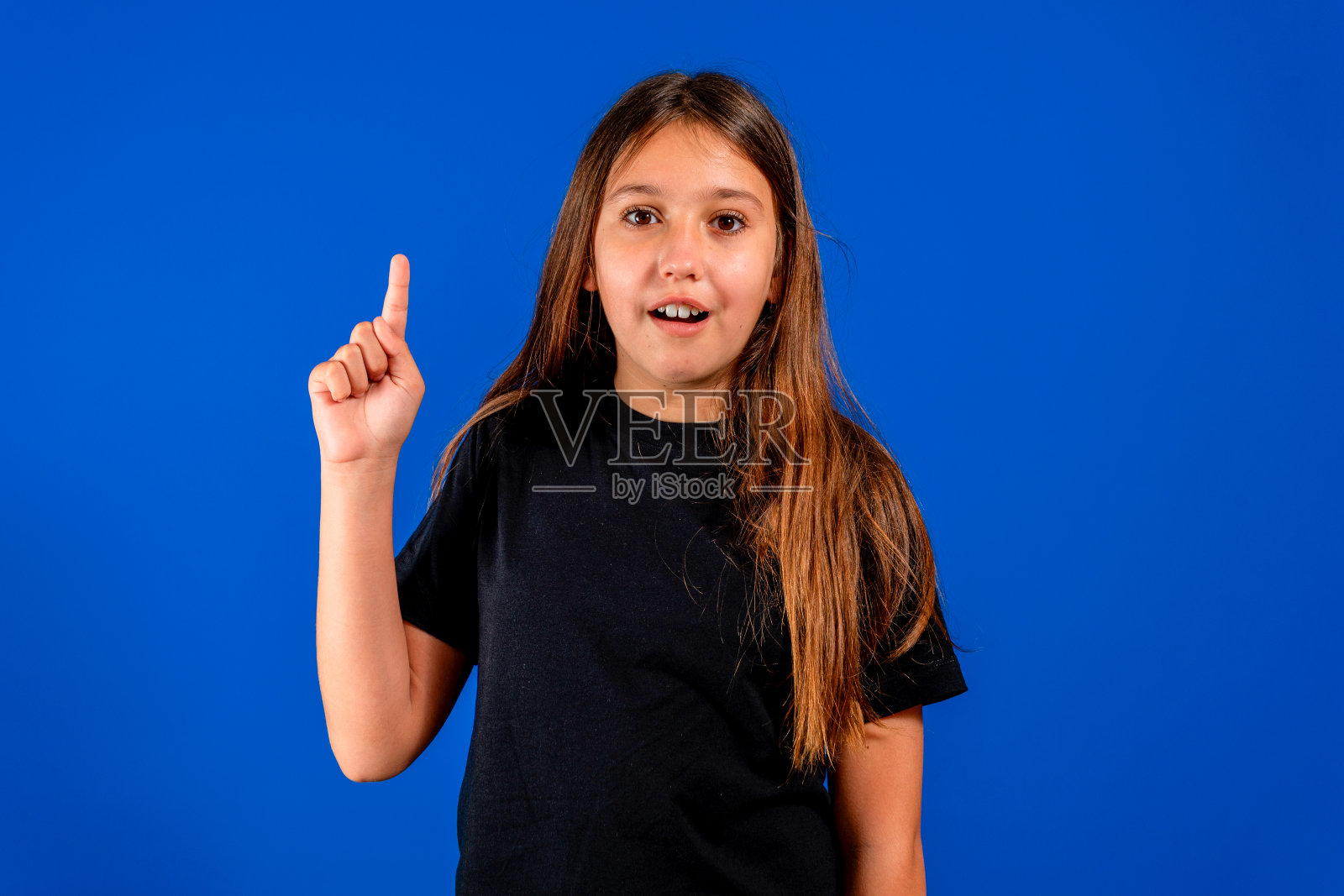 漂亮的西班牙裔少女微笑着举起食指，主动让自己采取行动。积极的态度。将概念照片摄影图片