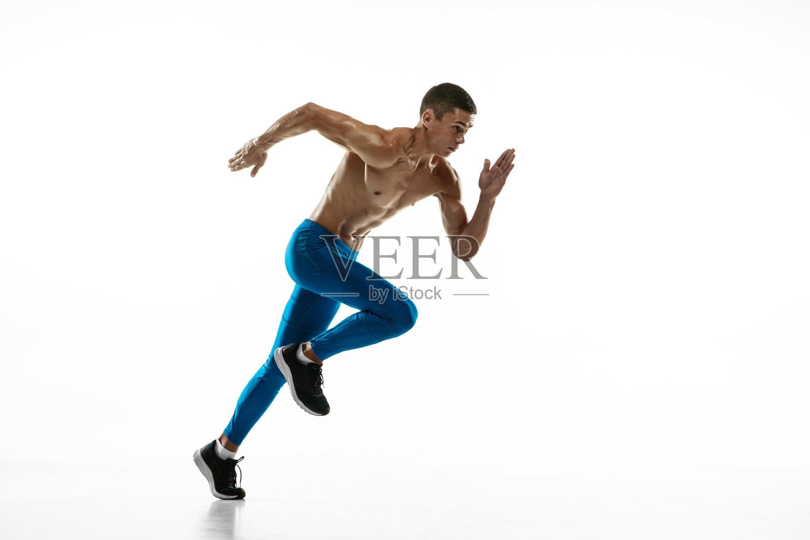 一名白人职业男性运动员，跑步训练隔离在白人工作室背景下。肌肉,运动的人。运动的概念，健康的生活方式照片摄影图片