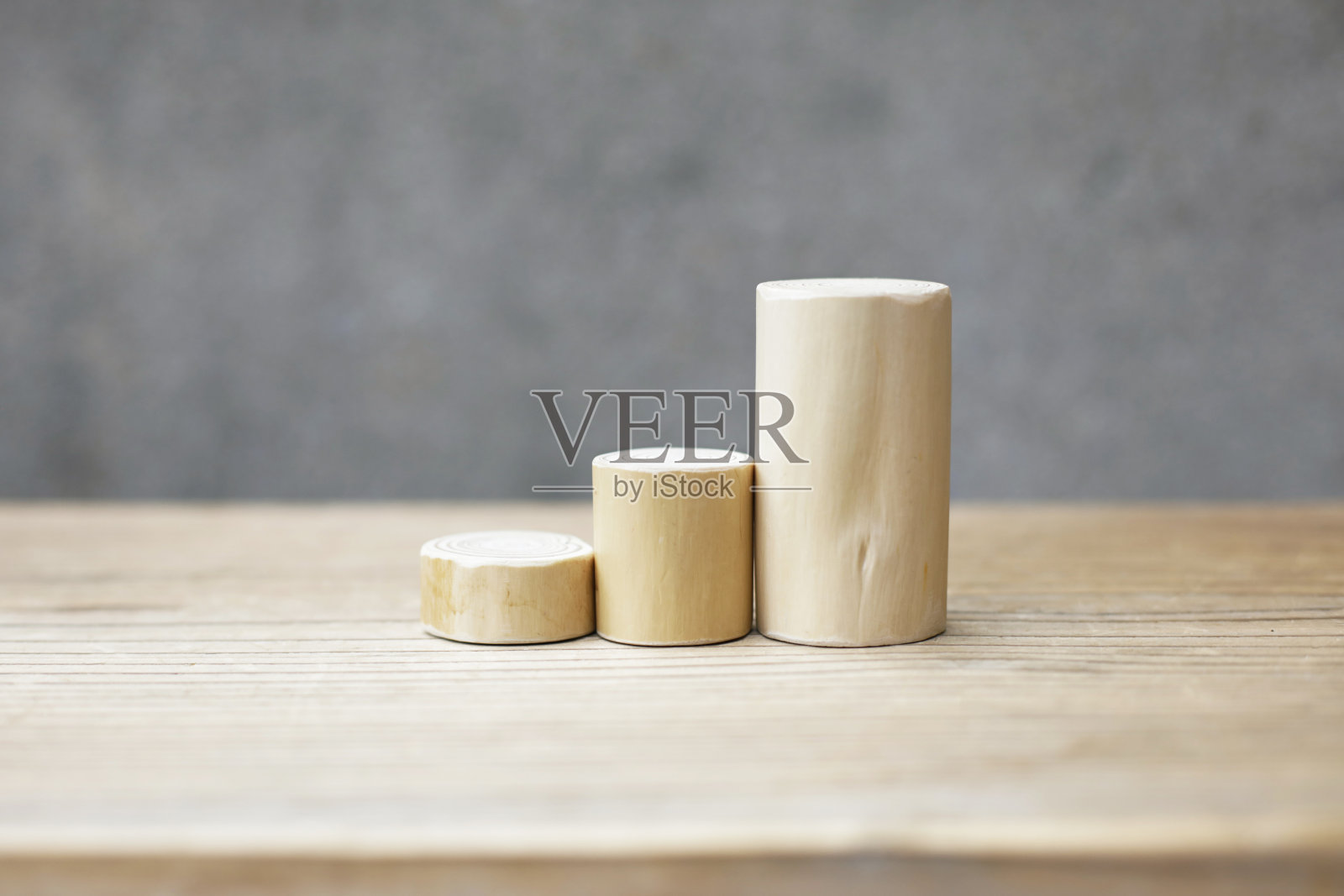 木桌上的薄而短的无皮原木块。无树皮的雪松原木排列紧密在一起，在木制背景的高度。照片摄影图片