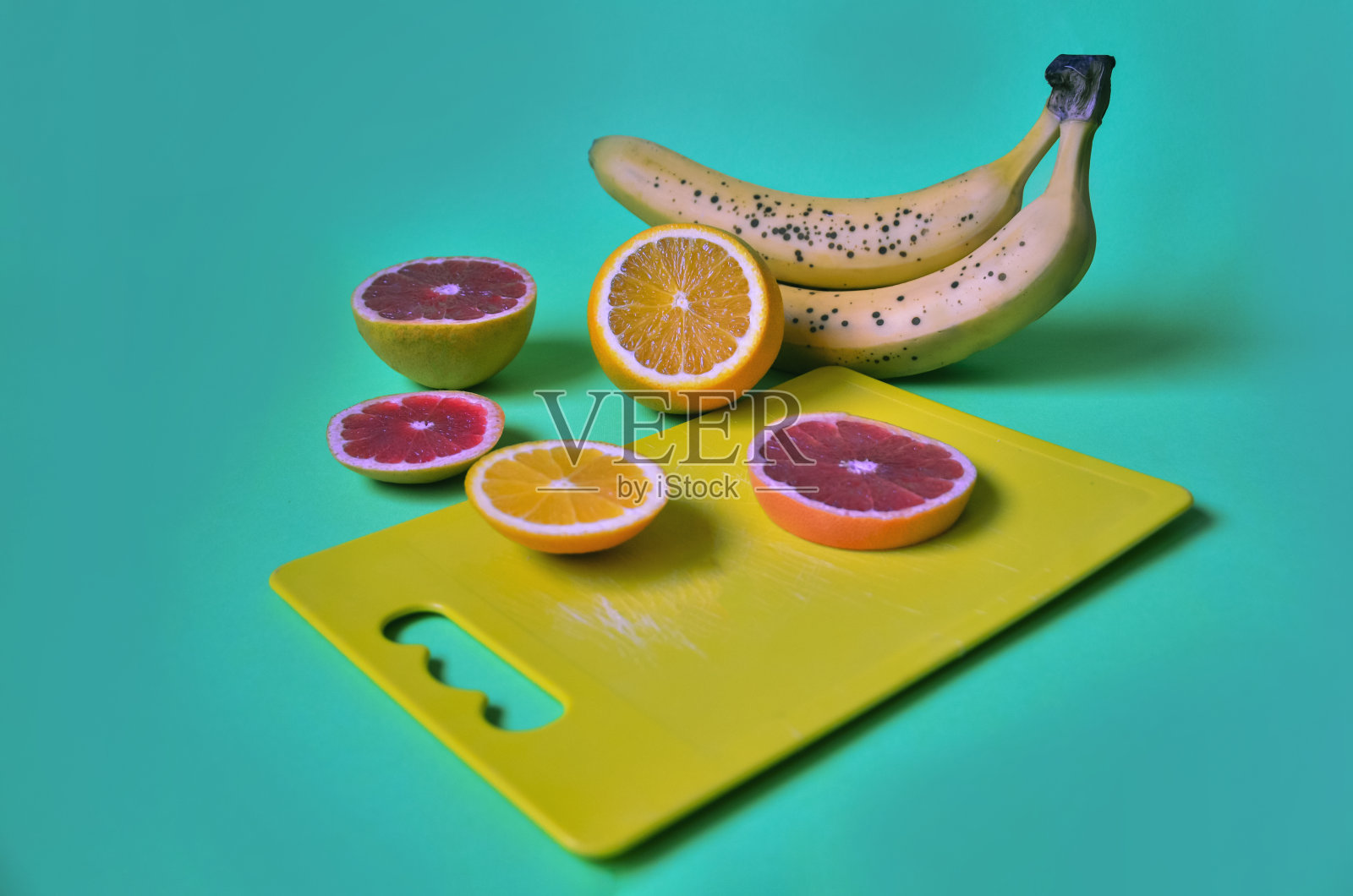 香蕉和橙子和黄色的砧板照片摄影图片