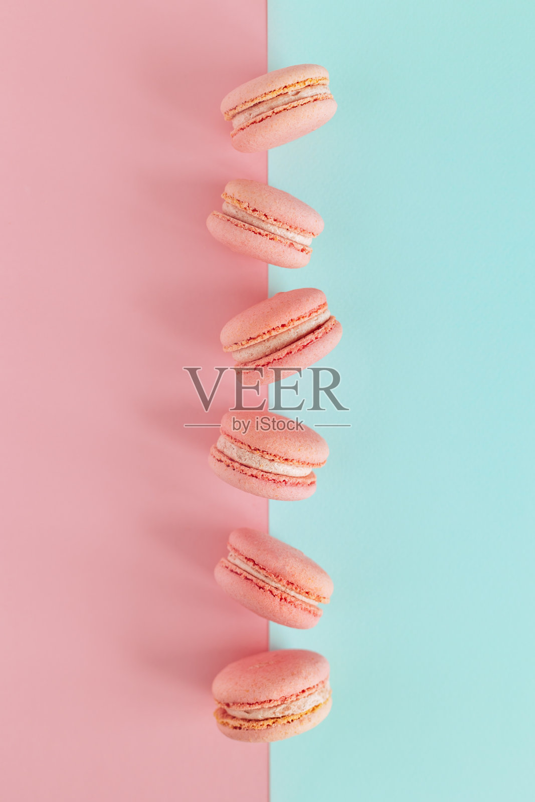 美味的法国粉色马卡龙，蓝色和粉色的柔和背景。照片摄影图片