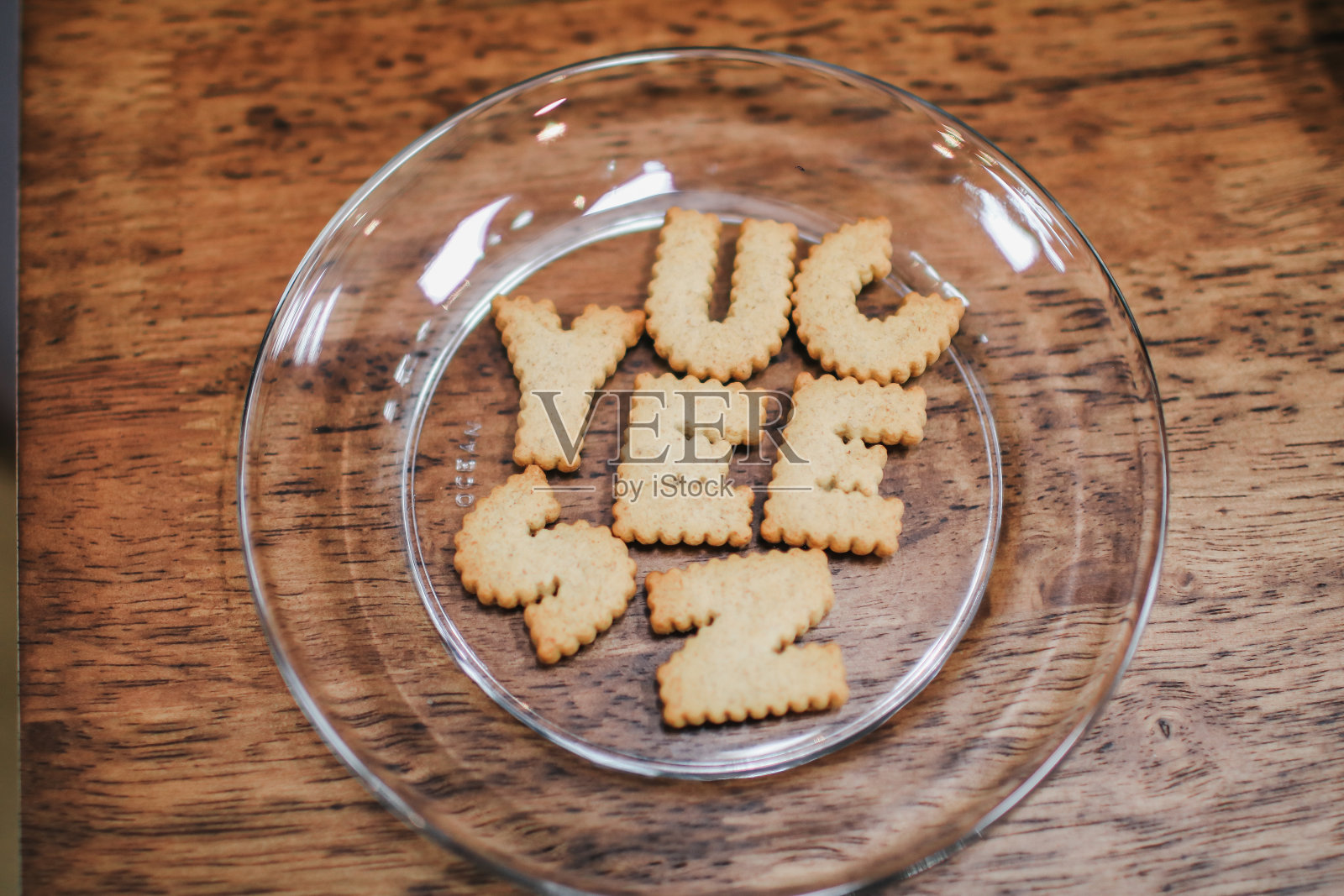 蓝色背景的木桌上有字母饼干盘。顶视图的照片。照片摄影图片