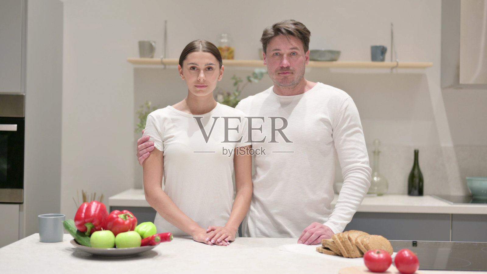 混血儿夫妇在厨房里看着摄像机照片摄影图片