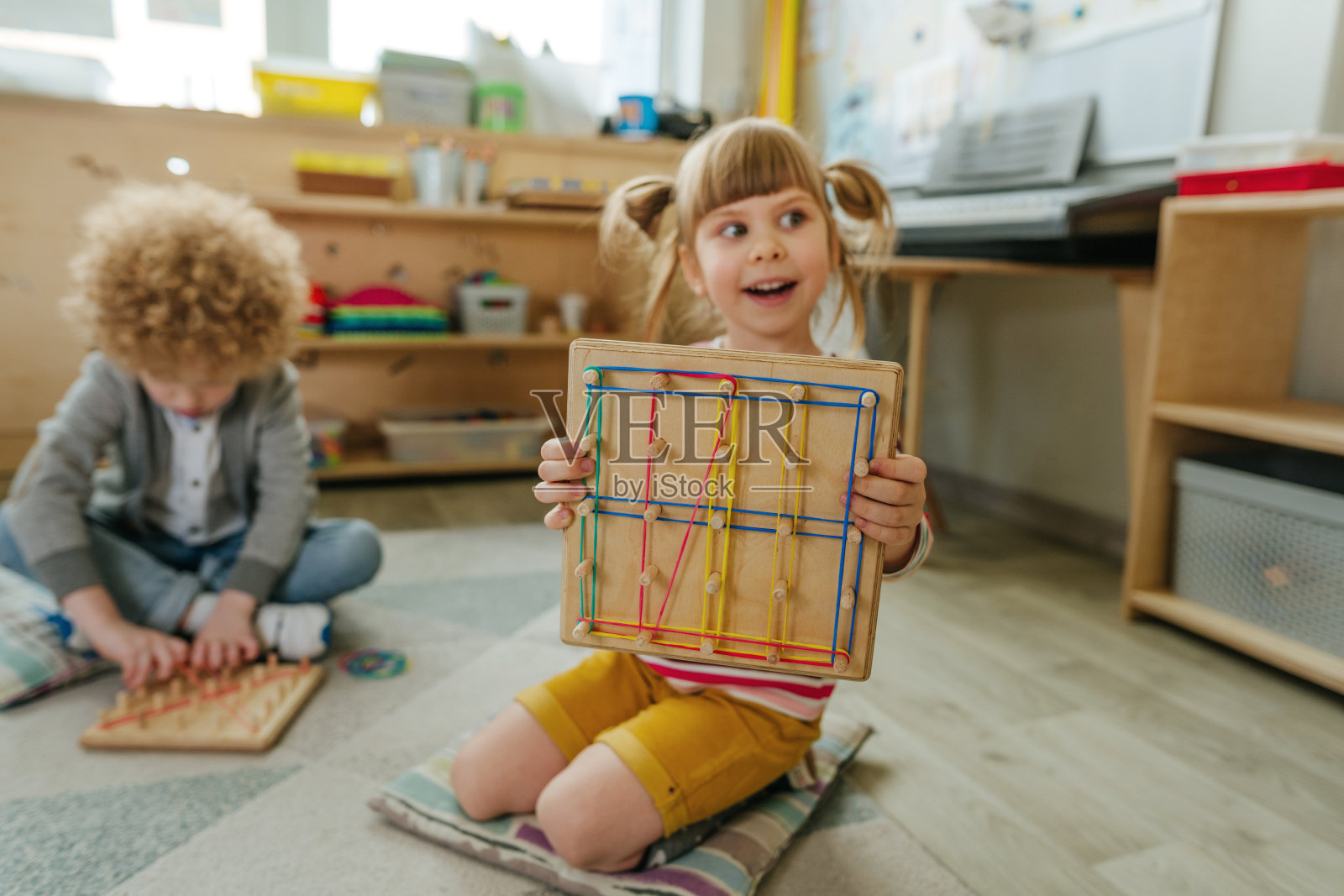 幼儿园小朋友用橡皮筋包地板玩照片摄影图片