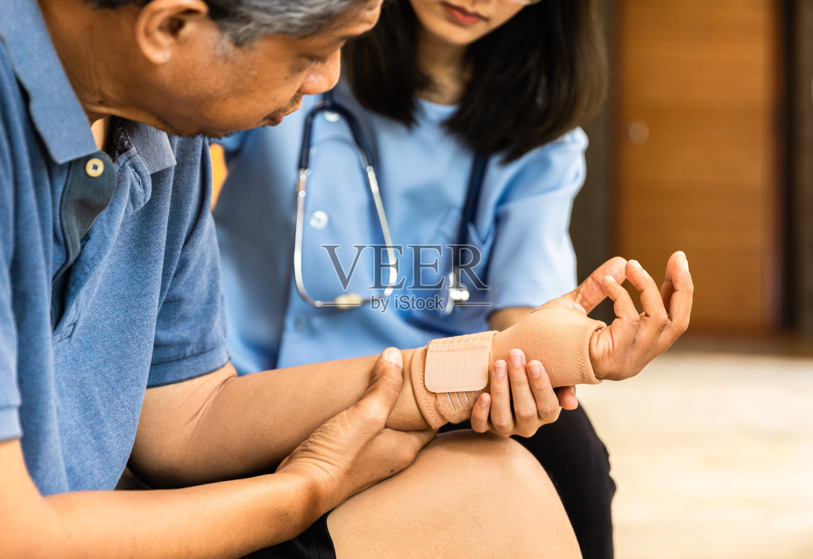 卫生视察员和家访期间的一名老年妇女。在病毒流行期间，一位担心的老人和她的全科医生交谈。照片摄影图片