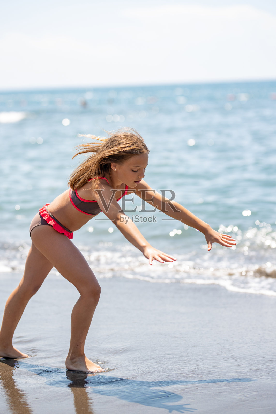 十几岁的女孩在海滩上练习体操照片摄影图片