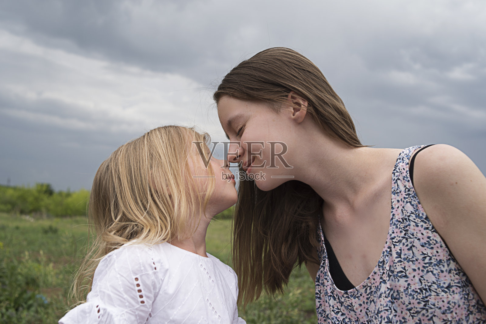 姐妹亲吻。照片摄影图片