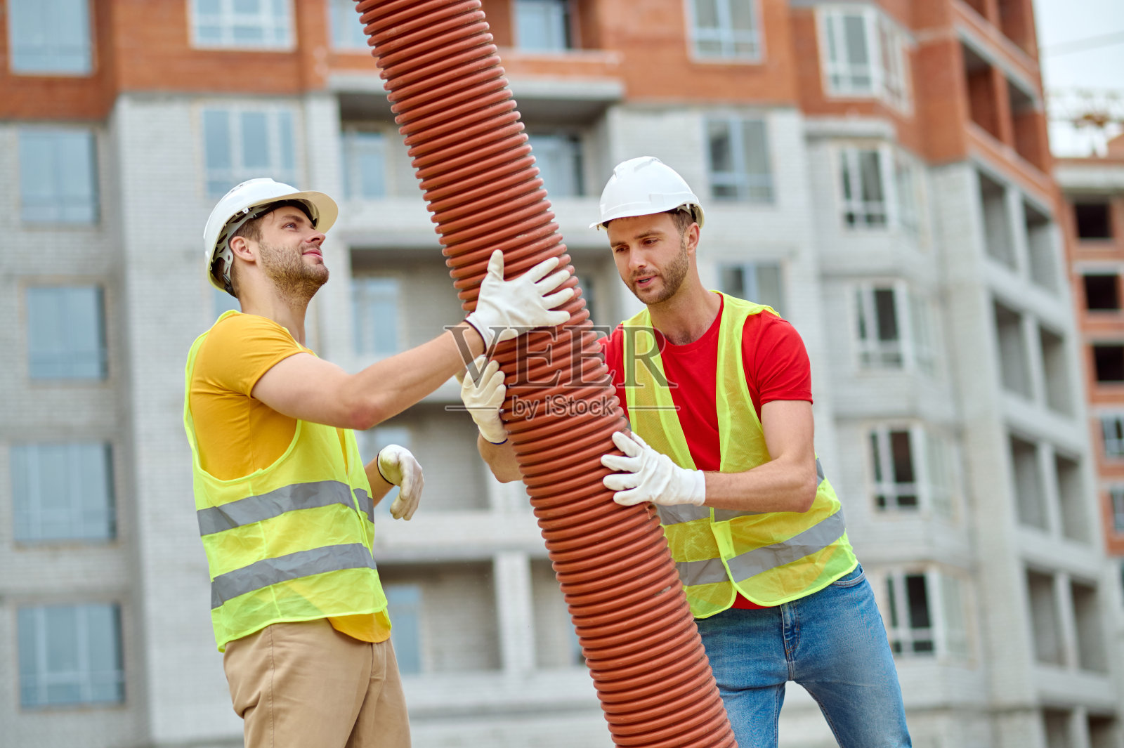 有经验的白人工人戴着安全帽安装排水系统照片摄影图片