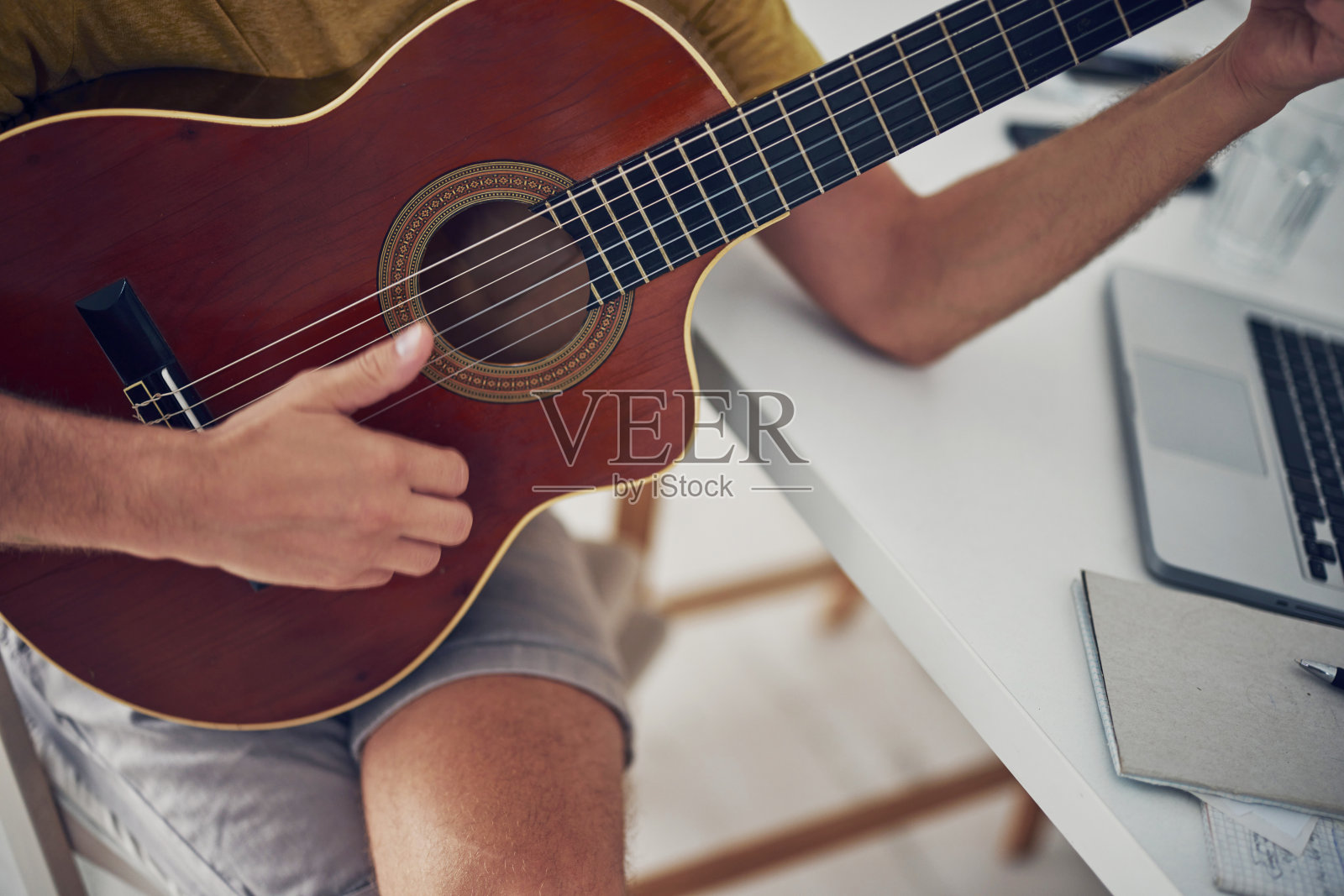 男人在家里弹吉他。照片摄影图片