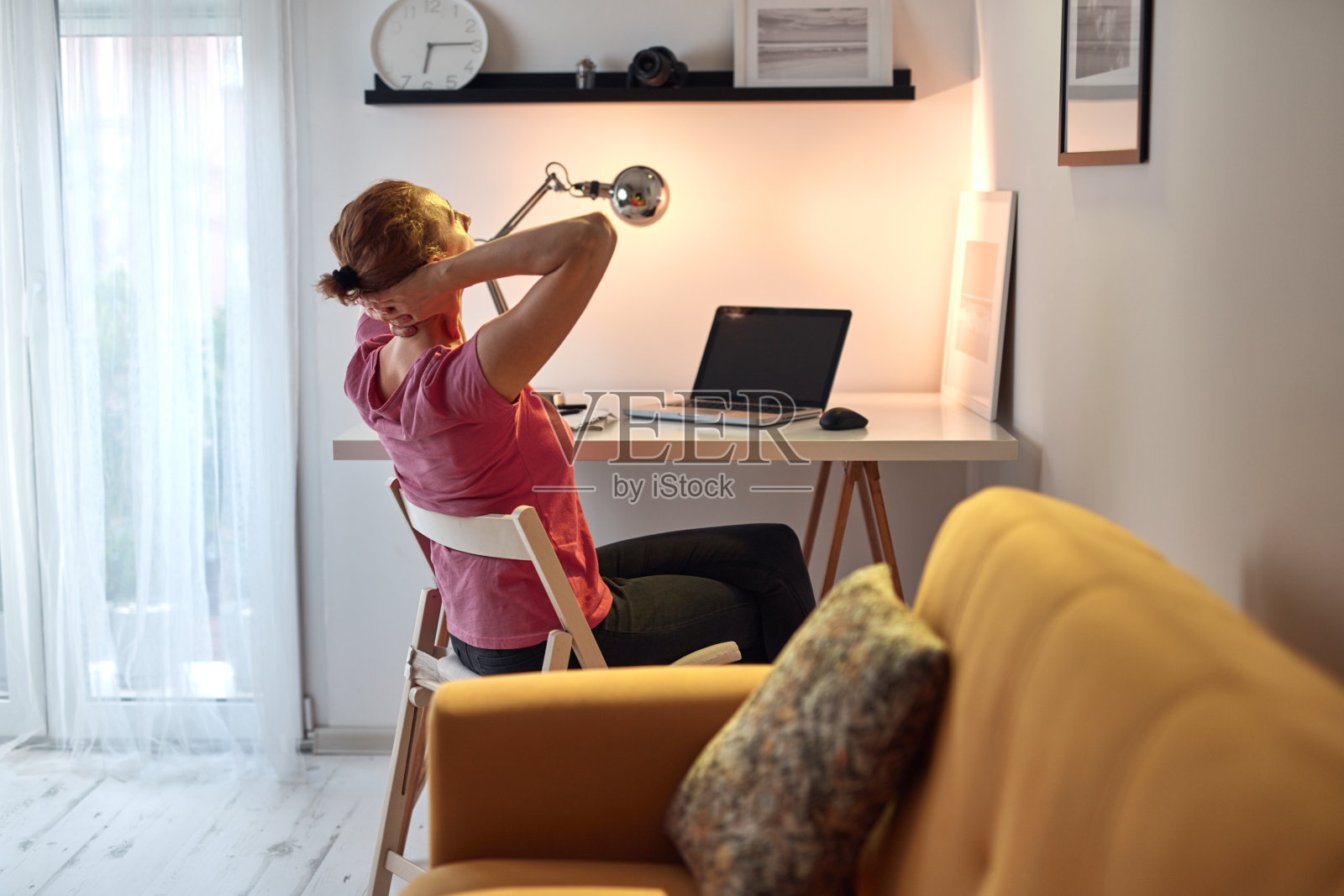 在家里用笔记本电脑工作，脖子疼的女人。照片摄影图片