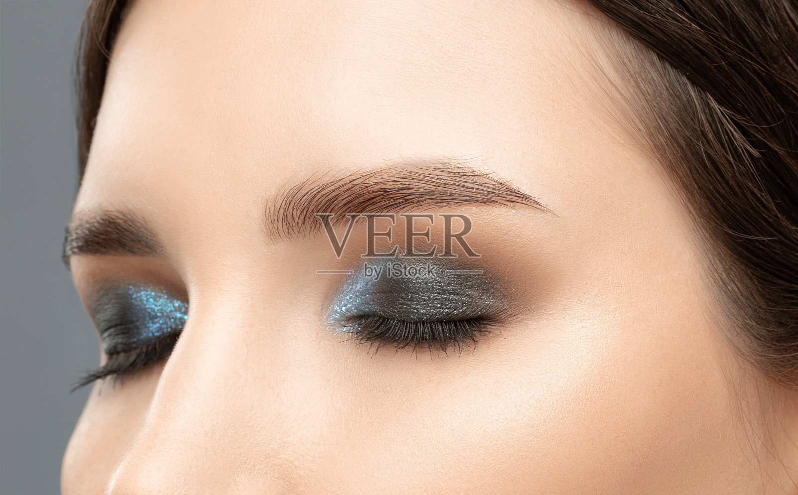 美丽的女人有着长长的睫毛，漂亮的妆容和浓眉。专业化妆、美容护肤。照片摄影图片