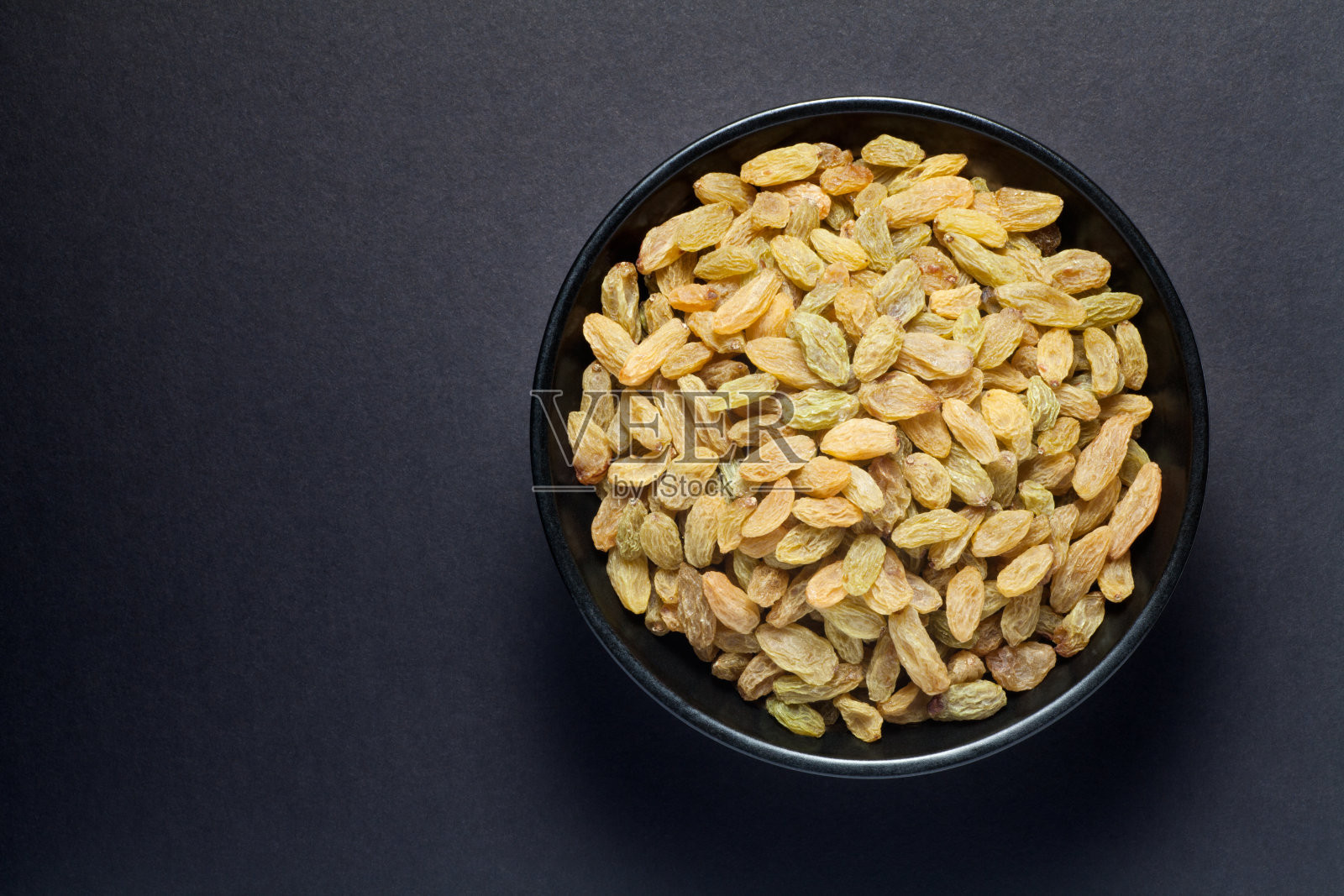 黑色的碗里有葡萄干照片摄影图片