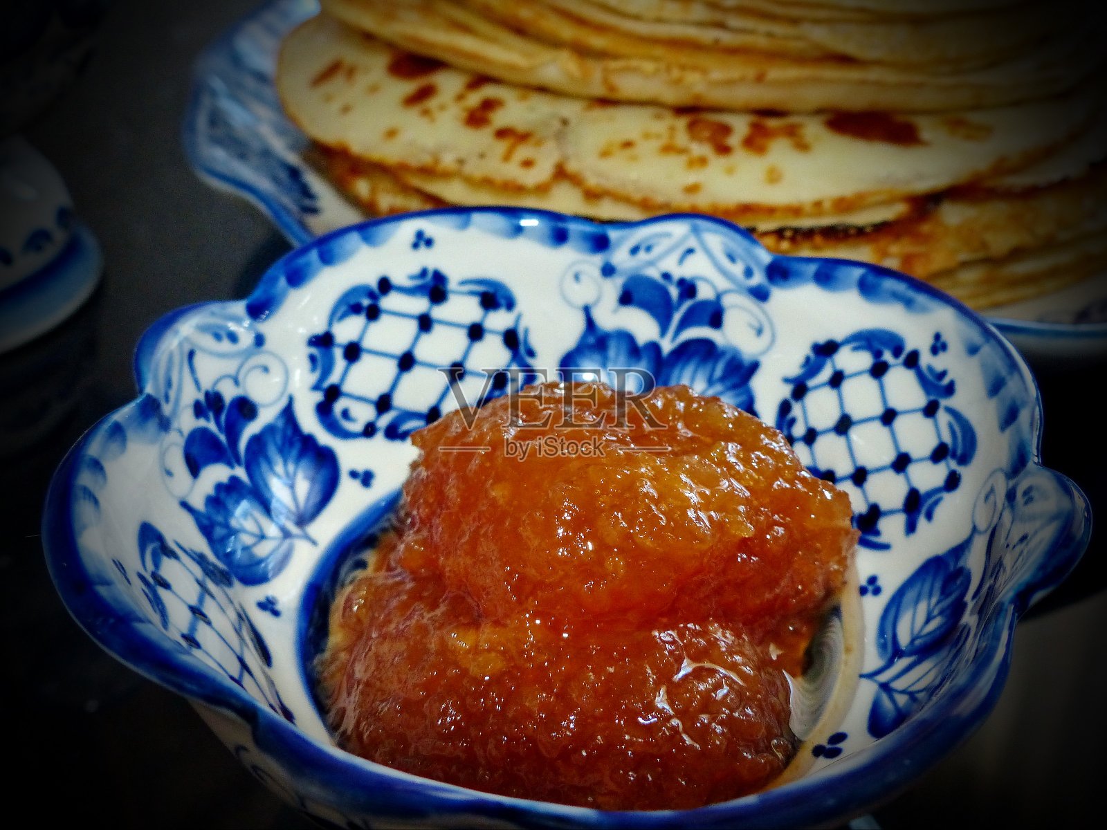 煎饼和果酱。忏悔节。Maslenitsa是一个传统的东部斯拉夫节日，在大斋节前一周庆祝。俄罗斯传统Gzhel风格的餐具——用于生产陶瓷和瓷器的民间工艺照片摄影图片